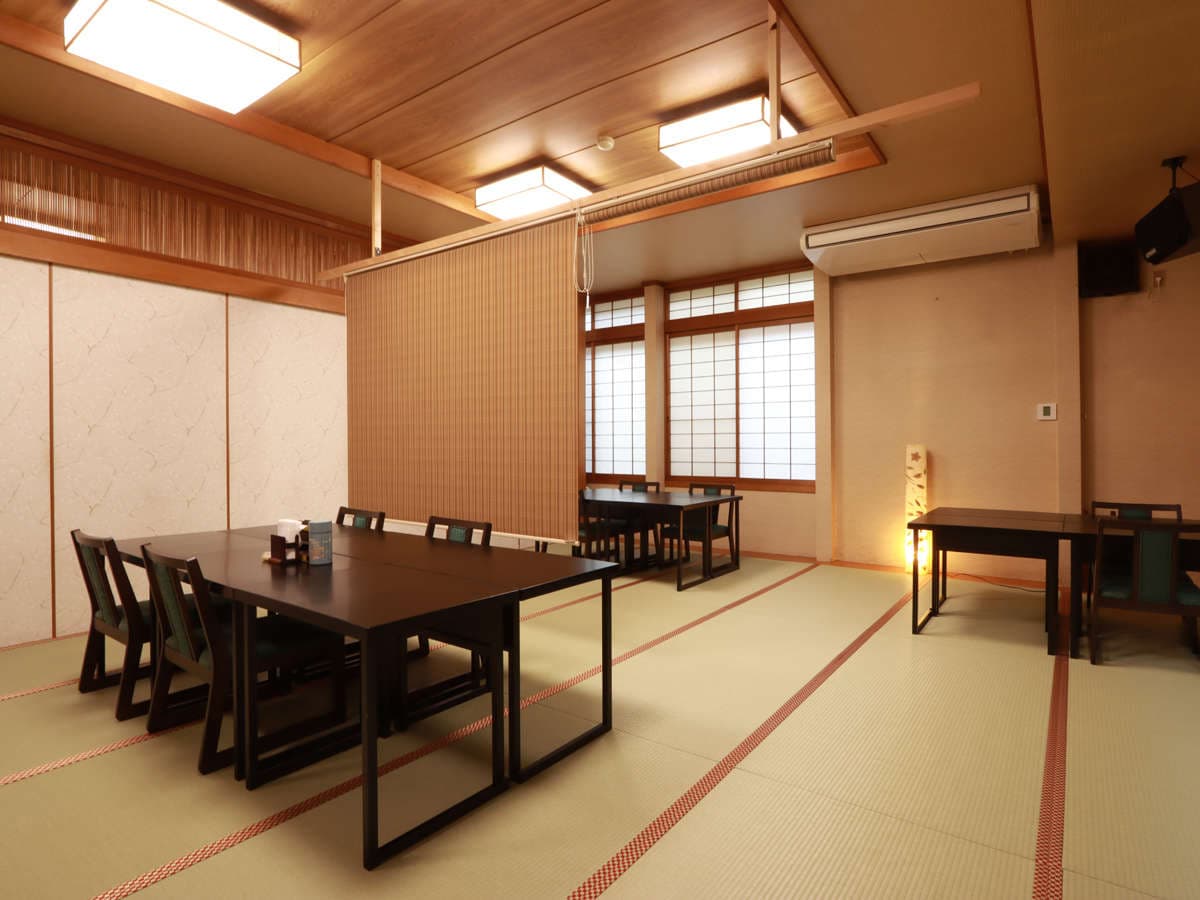 Private dining room at Ryokan Murayama with exposed dark beams, lantern lights and tatami flooring