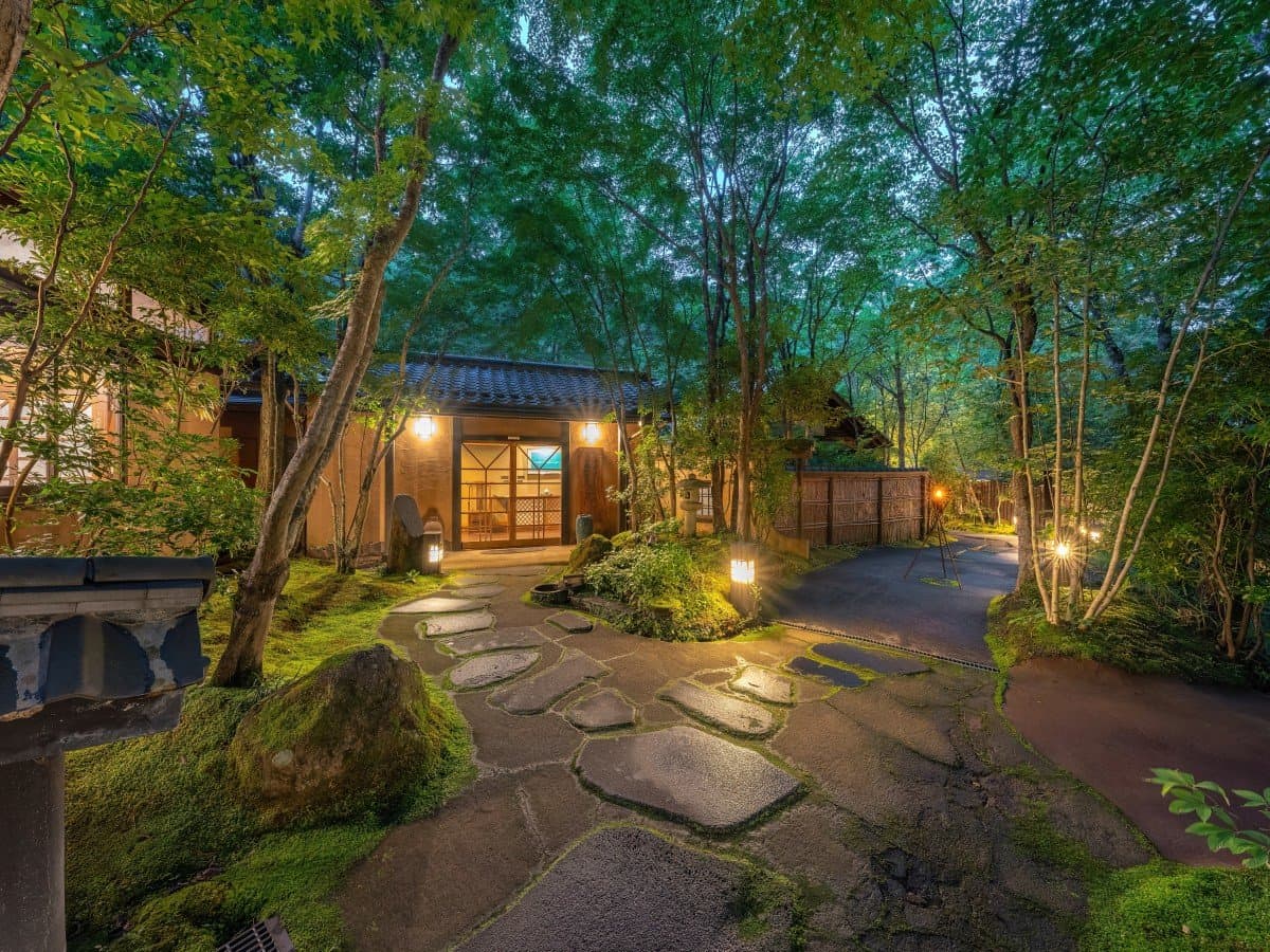 Oyado Nonohana stone-paved garden approach to the entrance among greenery in daylight