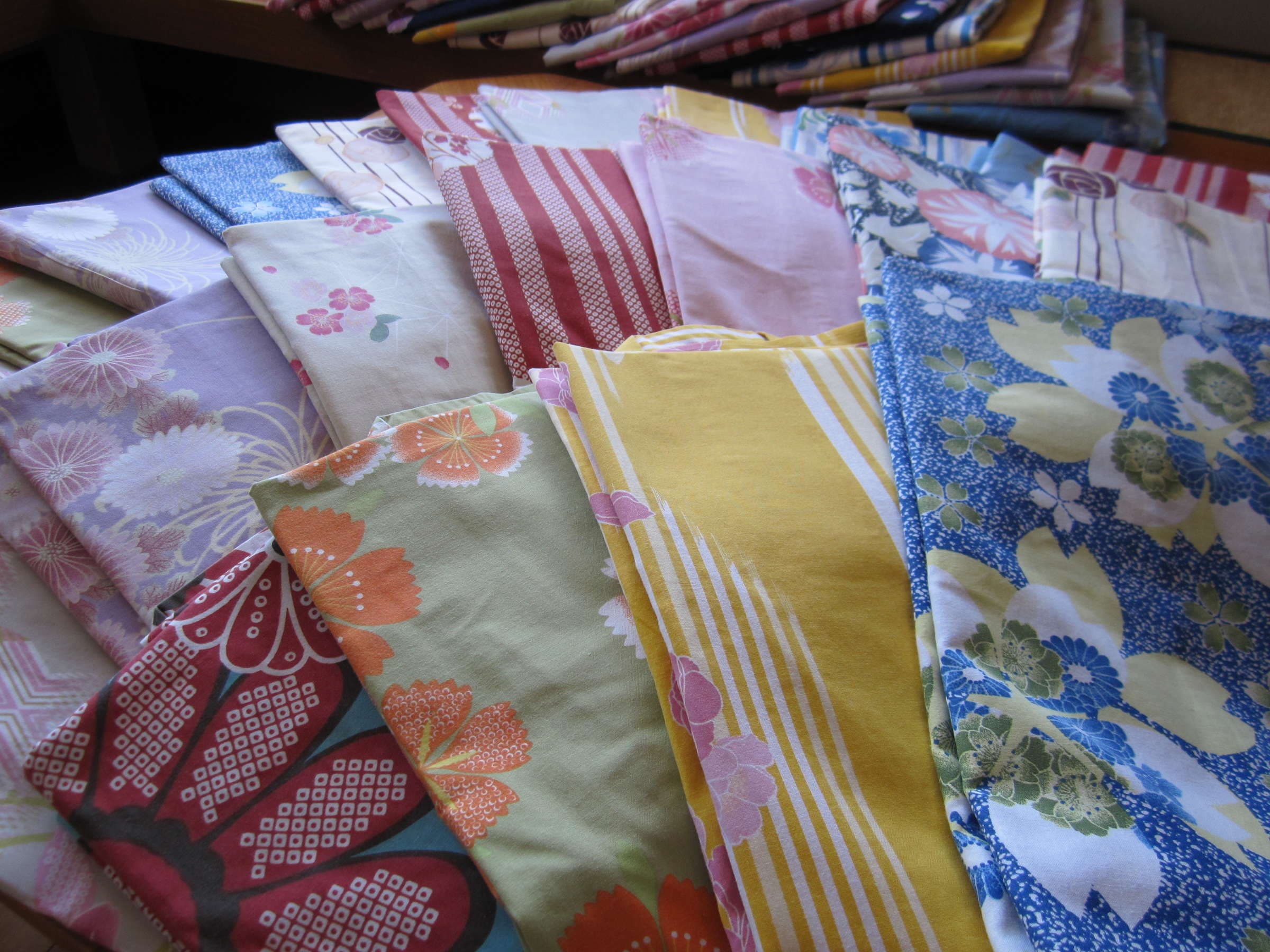 Display of colorful patterned yukata robes laid out for guests to choose at Nikko Senhime Monogatari