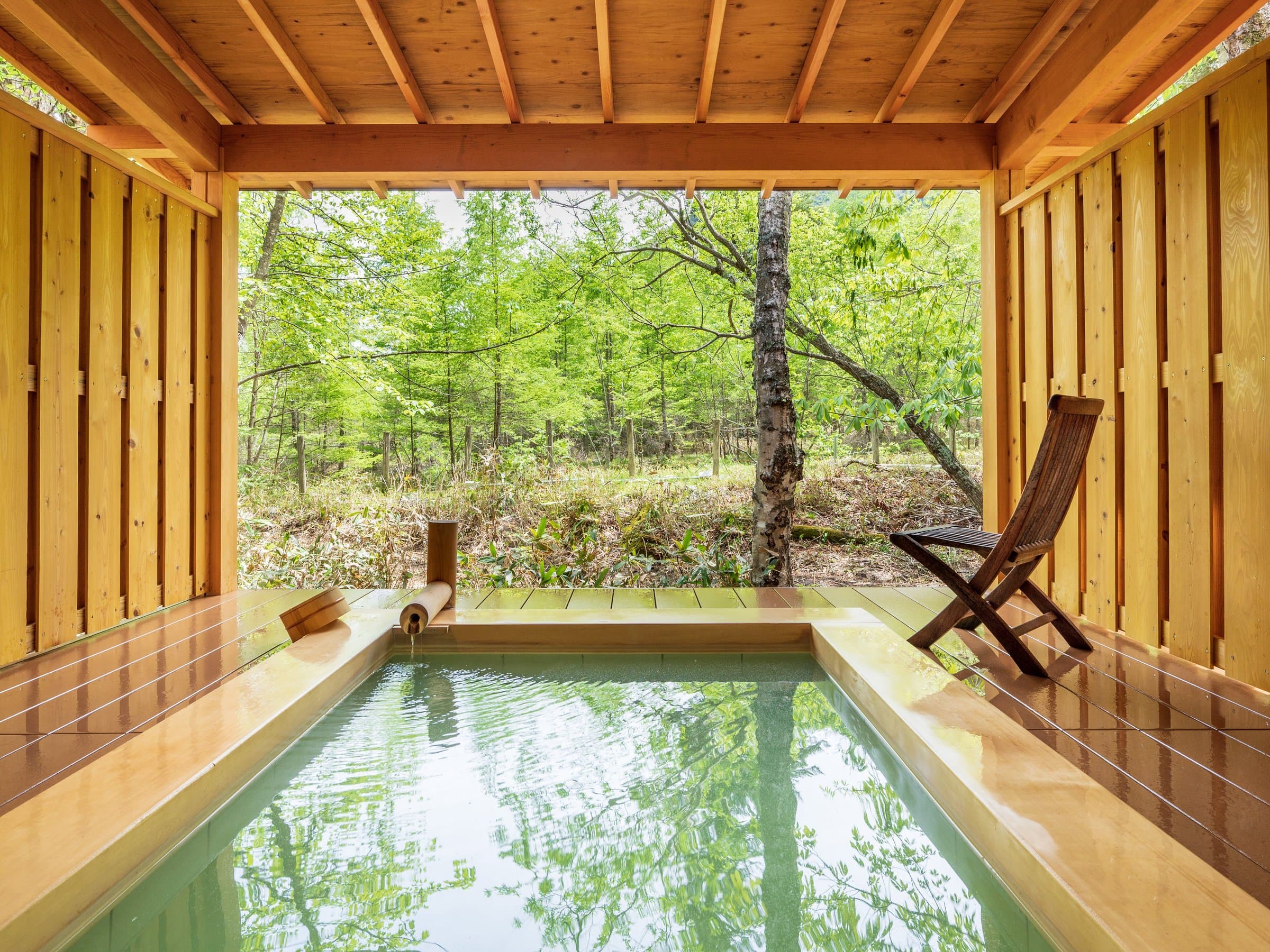 Cypress open-air bath at Okunikko Yuno-mori framing a fresh-green forest view in Oku-Nikko Onsen