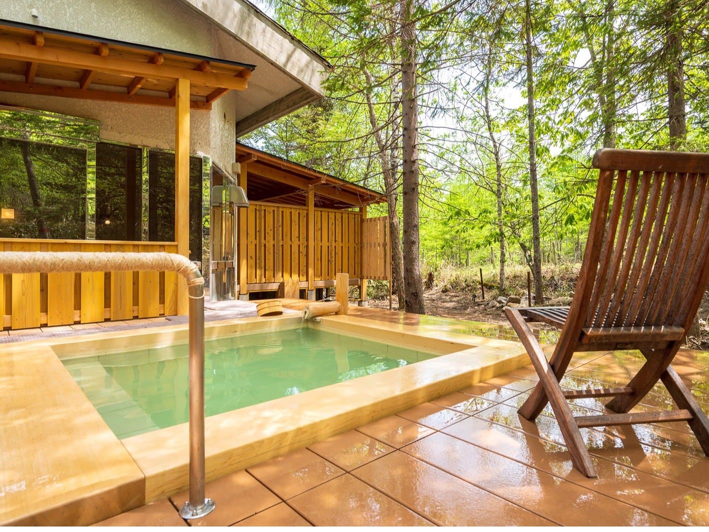 Private wooden rotenburo on a stone terrace surrounded by larch forest at Okunikko Yuno-mori