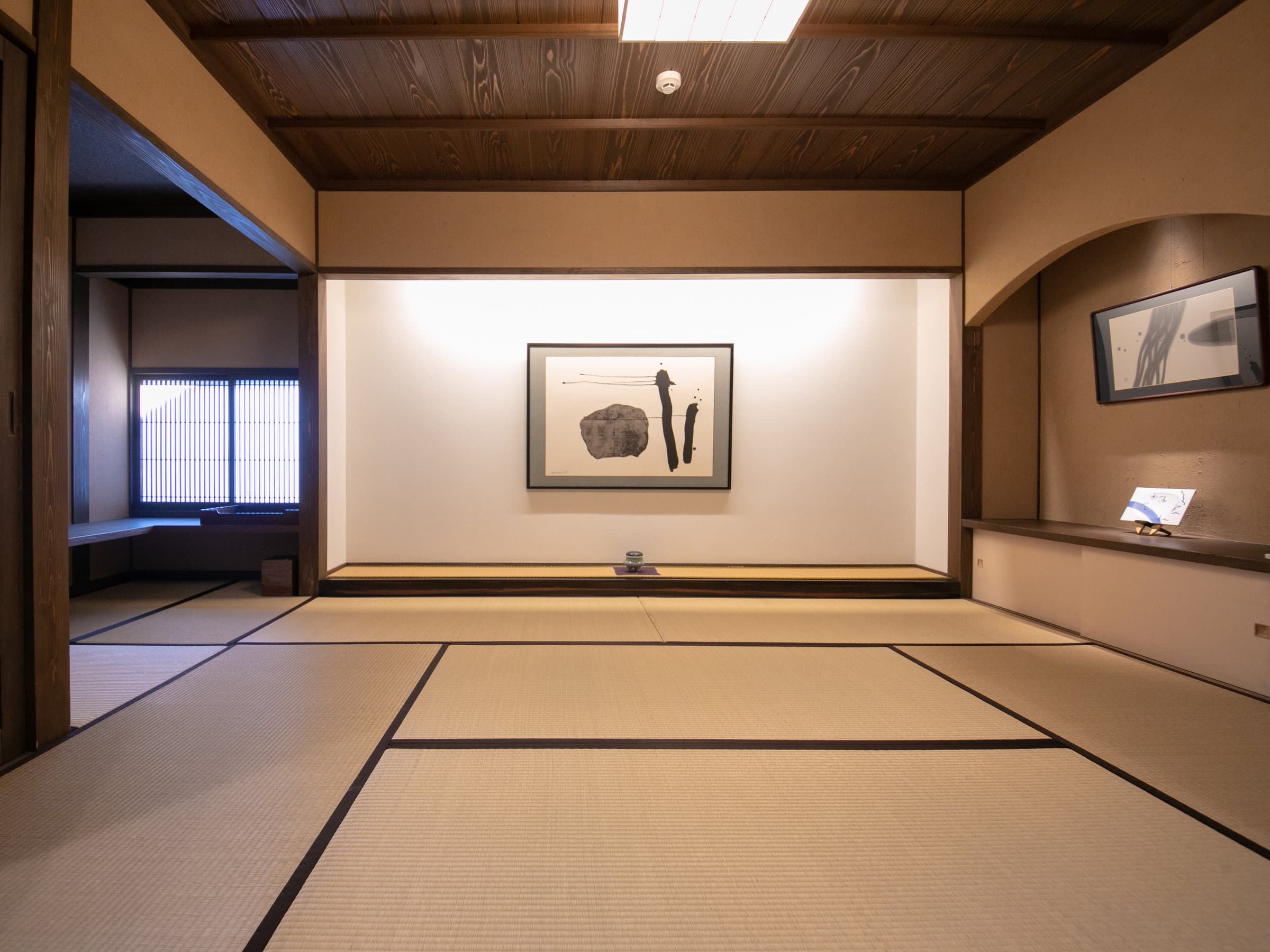 Spacious tatami guest room at Yufuin Bettei Itsuki with a tokonoma alcove displaying ink artwork
