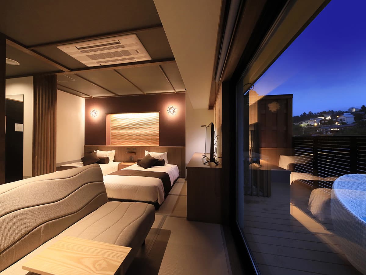 Private open-air bath at twilight under a wooden pergola with deep blue sky