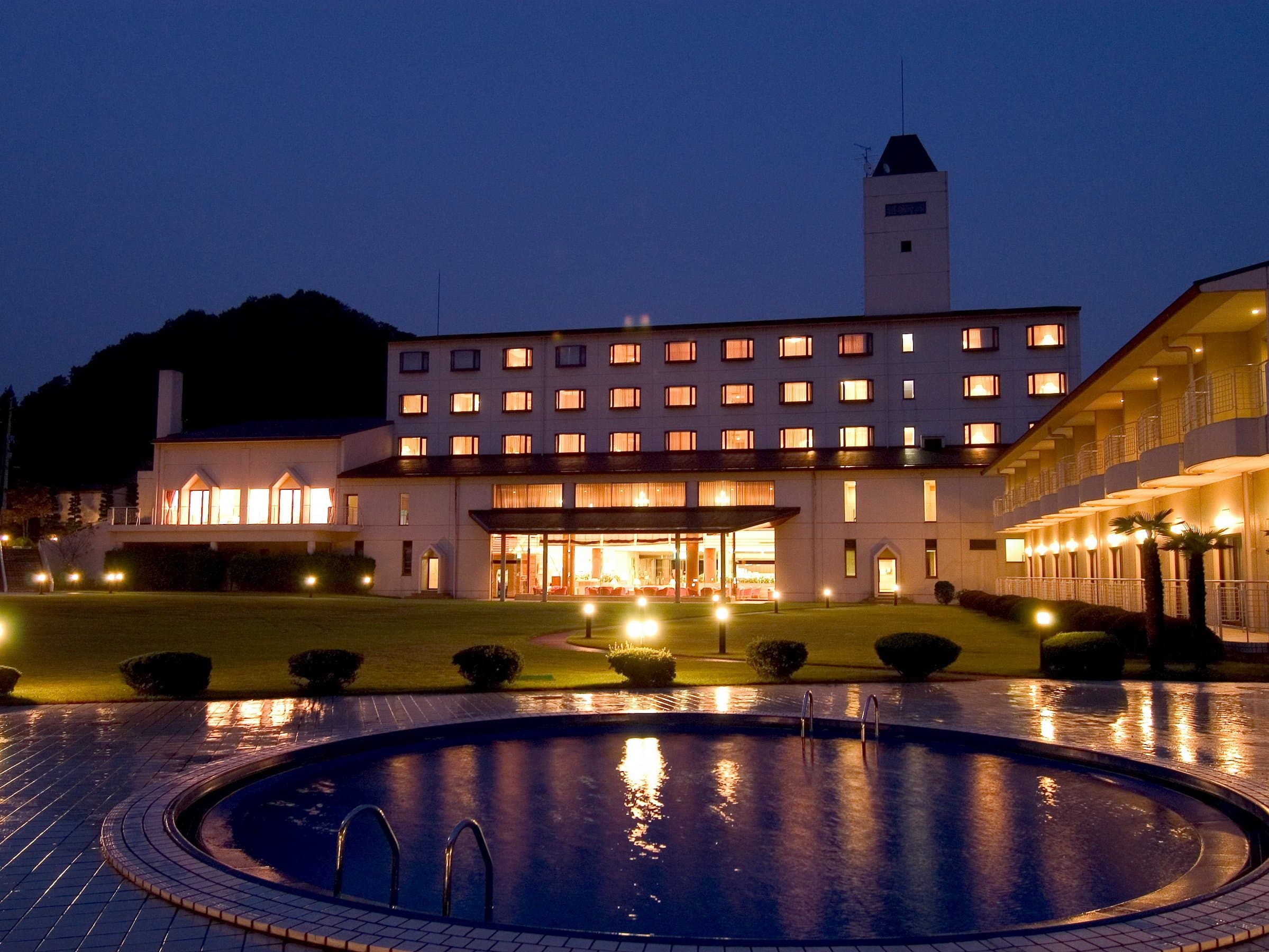 Akiu Resort Hotel Crescent illuminated at night with curved poolside reflection