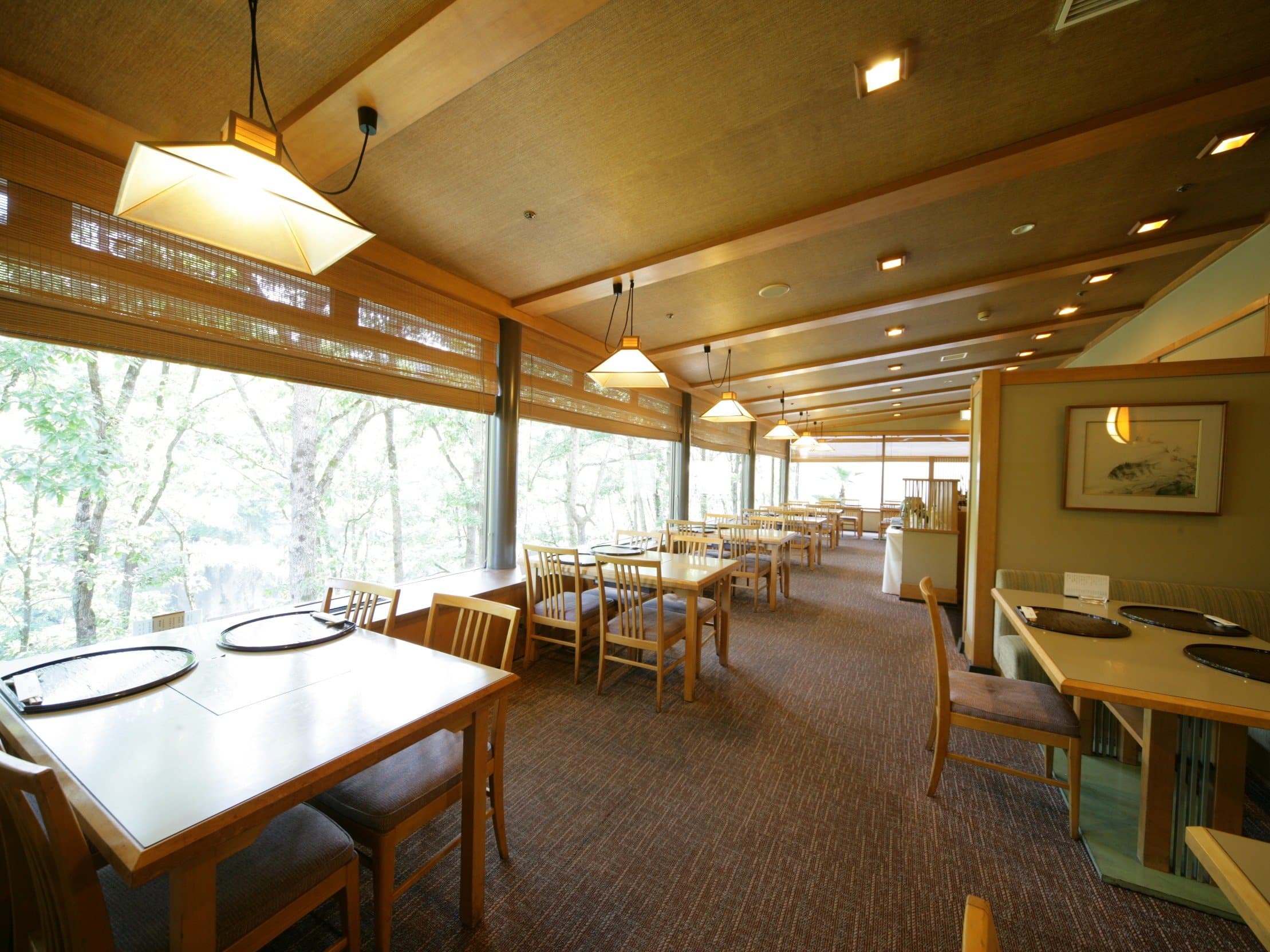 Forest-view restaurant dining hall with wood ceiling and large windows