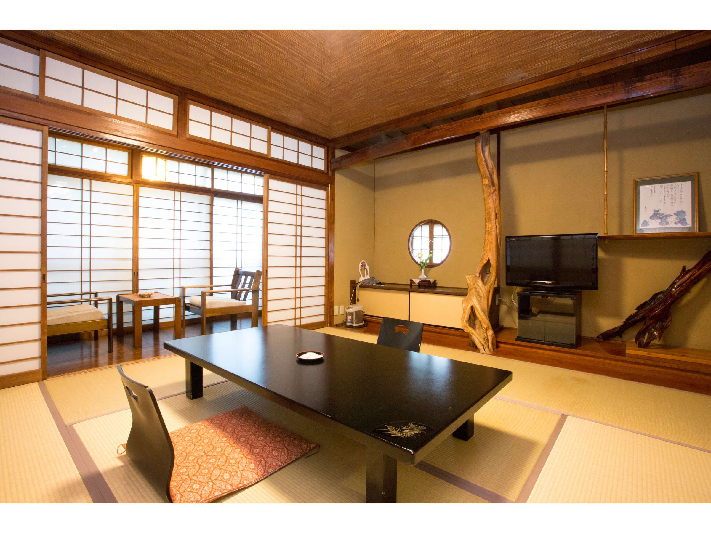 Yumerindo refined tatami guest room with round window, driftwood post and low table