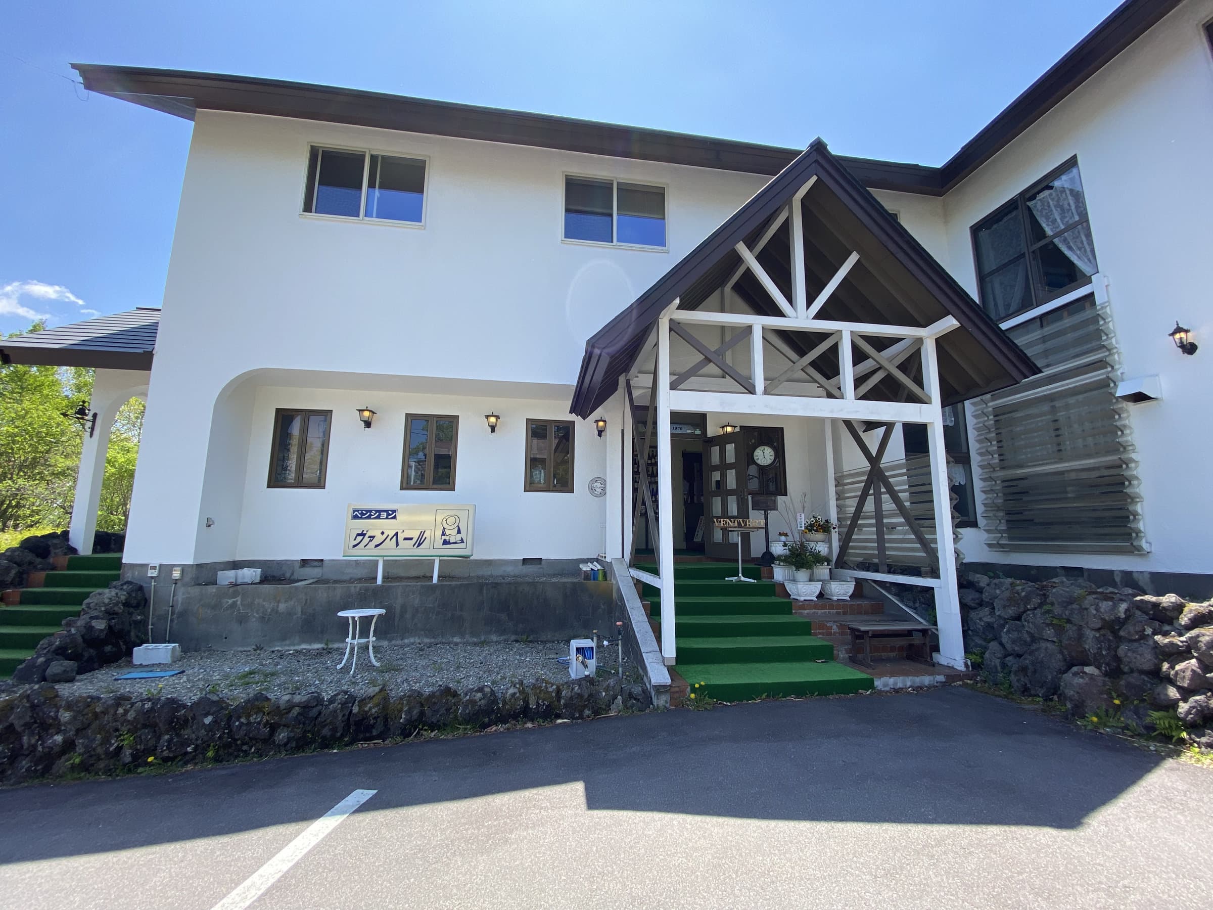 Kusatsu Onsen Vent Vert white pension-style building exterior with gabled timber entrance and signage in daylight