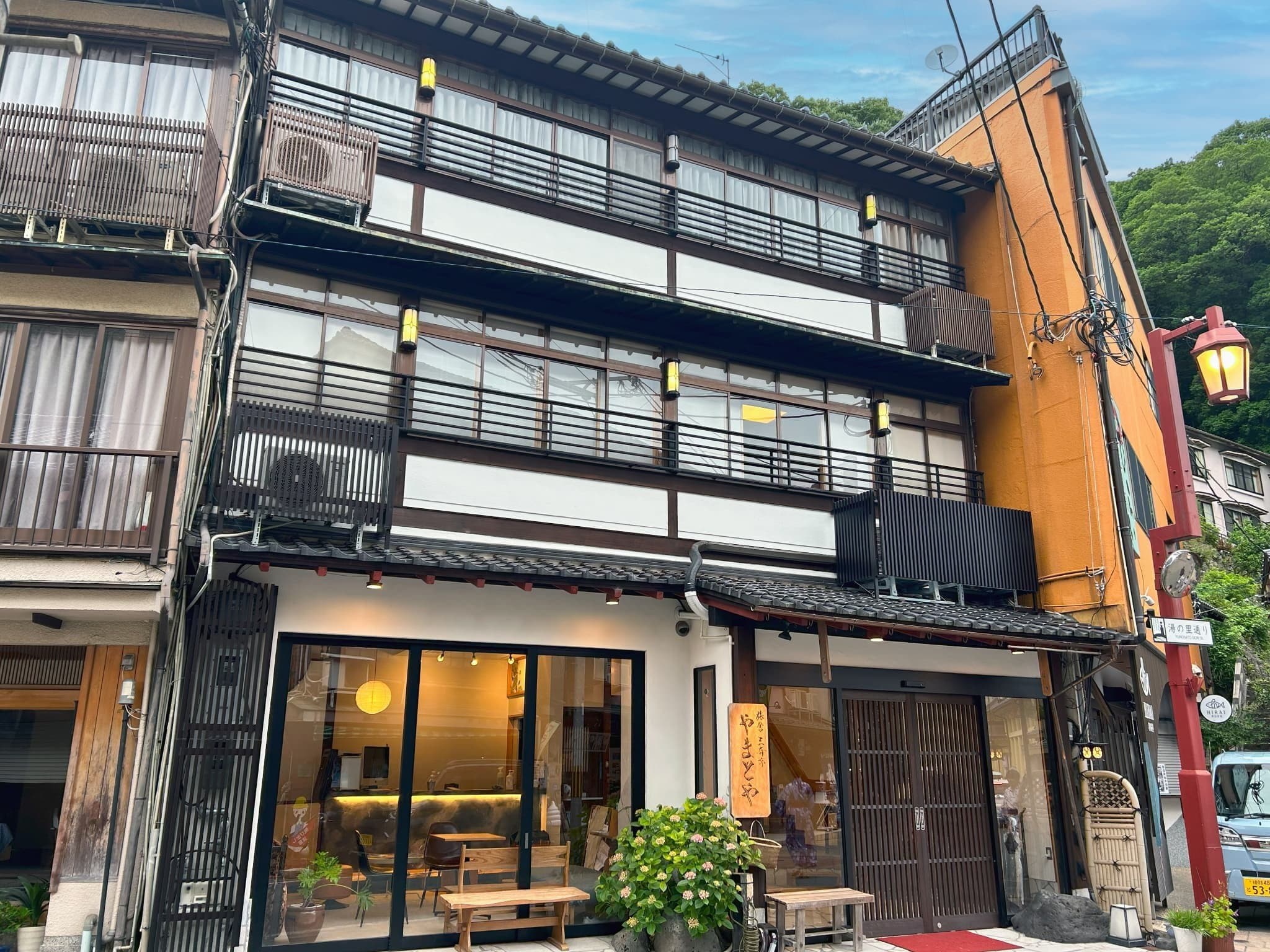Yamatoya Ryokan Kinosaki Onsen full three-story wood-and-plaster building exterior in daylight