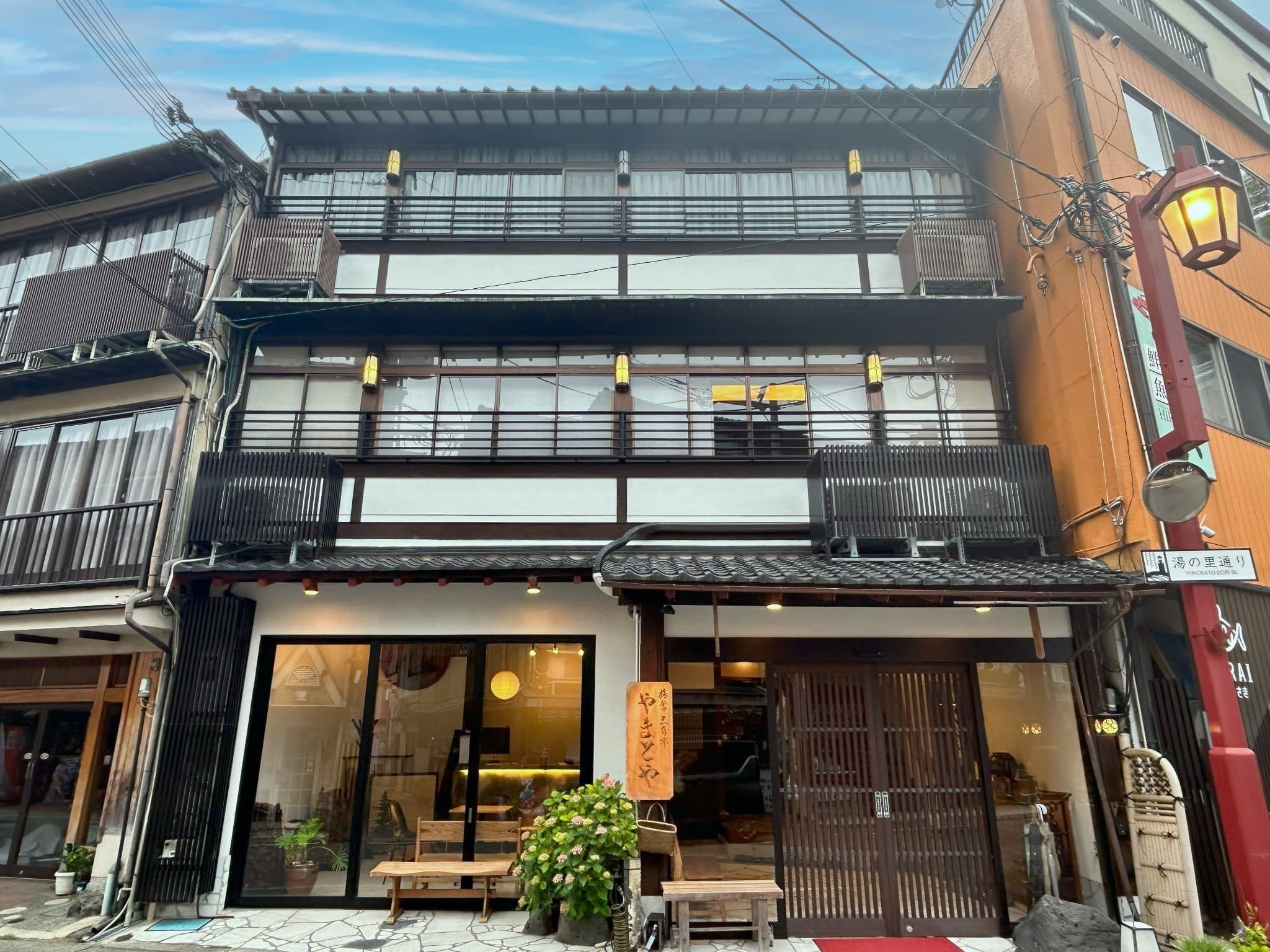 Yamatoya Ryokan Kinosaki Onsen facade with lattice windows and lit ground-floor entrance