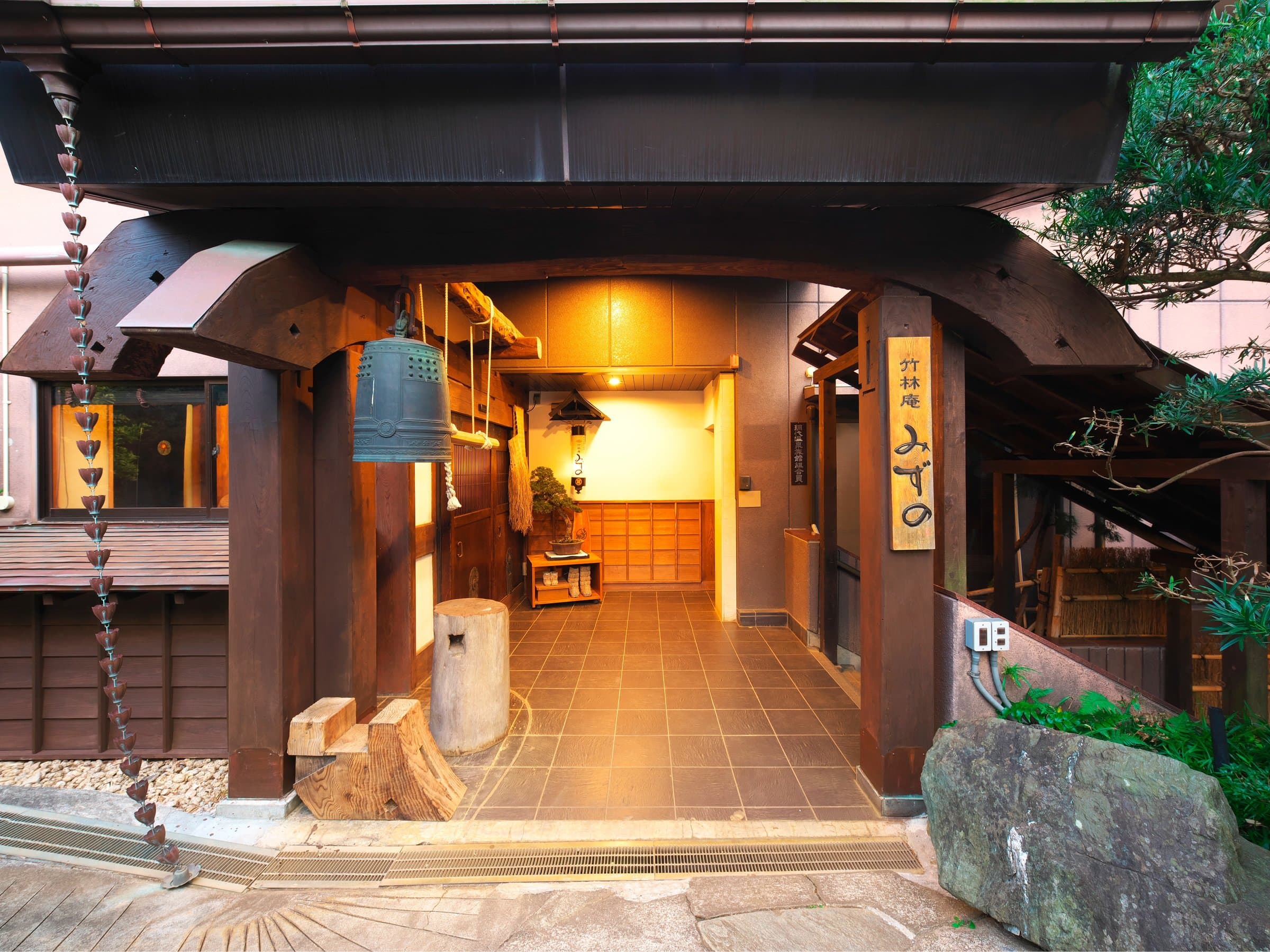 Traditional timber entrance and genkan of Chikurinan Mizuno with hanging bell and inn name plaque