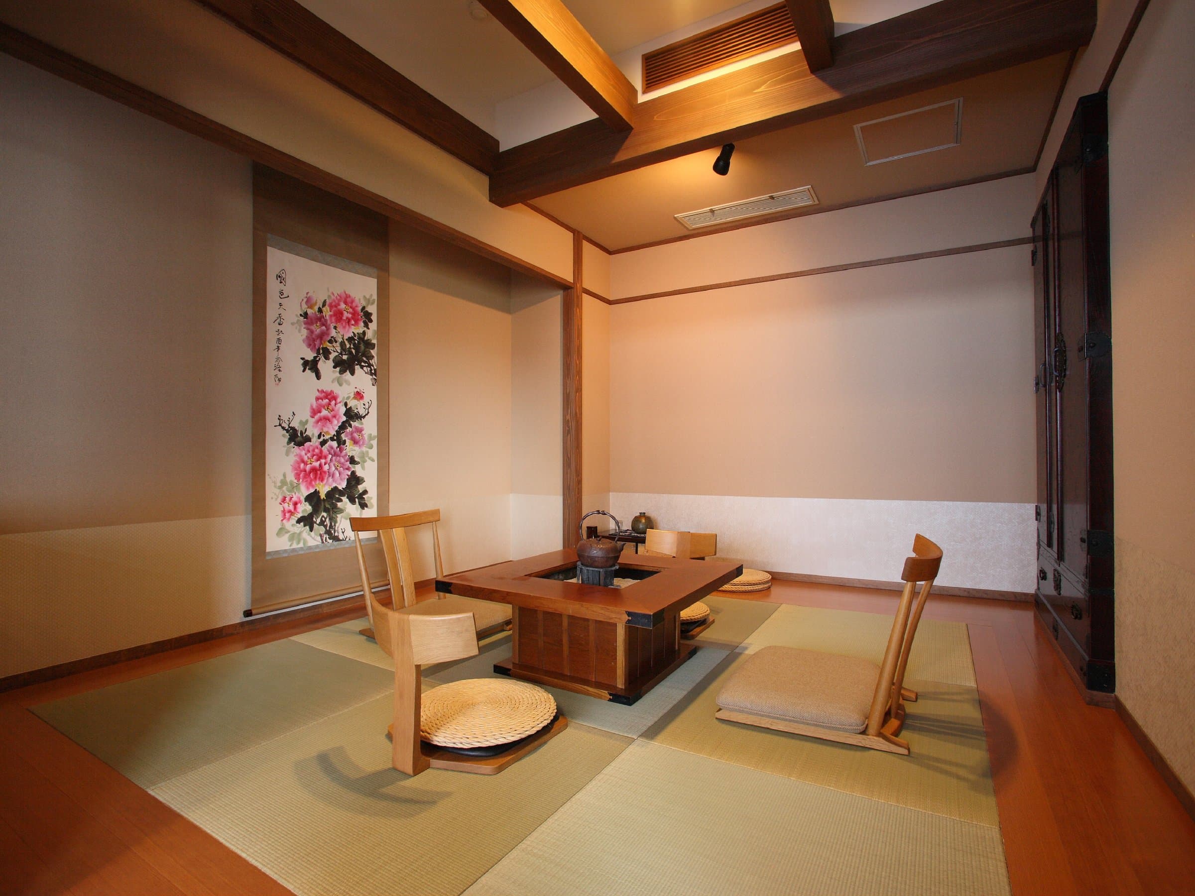 Traditional tatami guest room at Noshu Iroha with sunken irori hearth table and hanging flower scroll