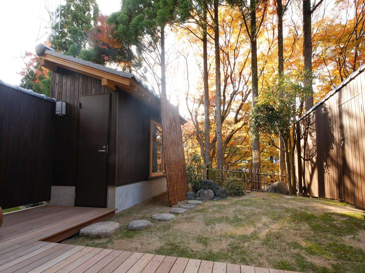 Spa Terrace Shisui timber building exterior surrounded by autumn-tinted Arima mountain foliage