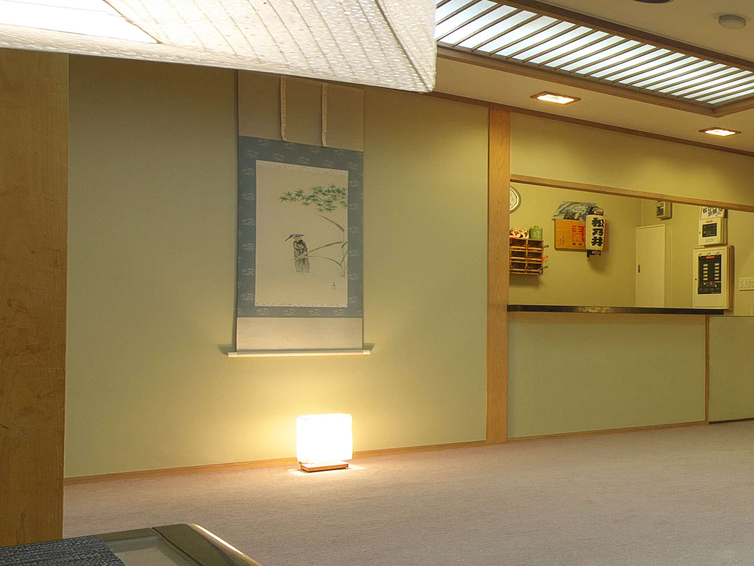 Lobby area with hanging scroll, paper lantern lamp and a recessed reception counter