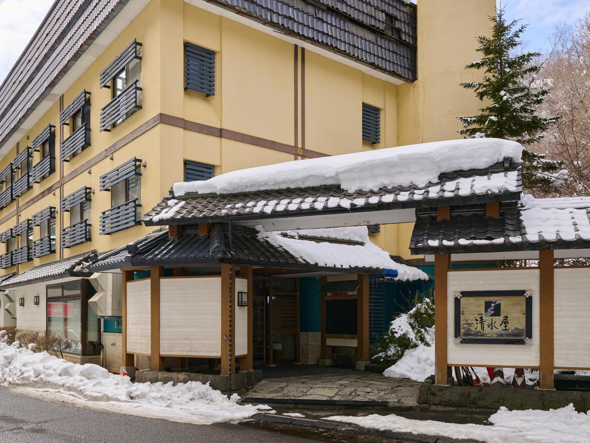 Traditional tiled-roof front entrance of Oyado Kiyomizuya in winter snow at Noboribetsu Onsen
