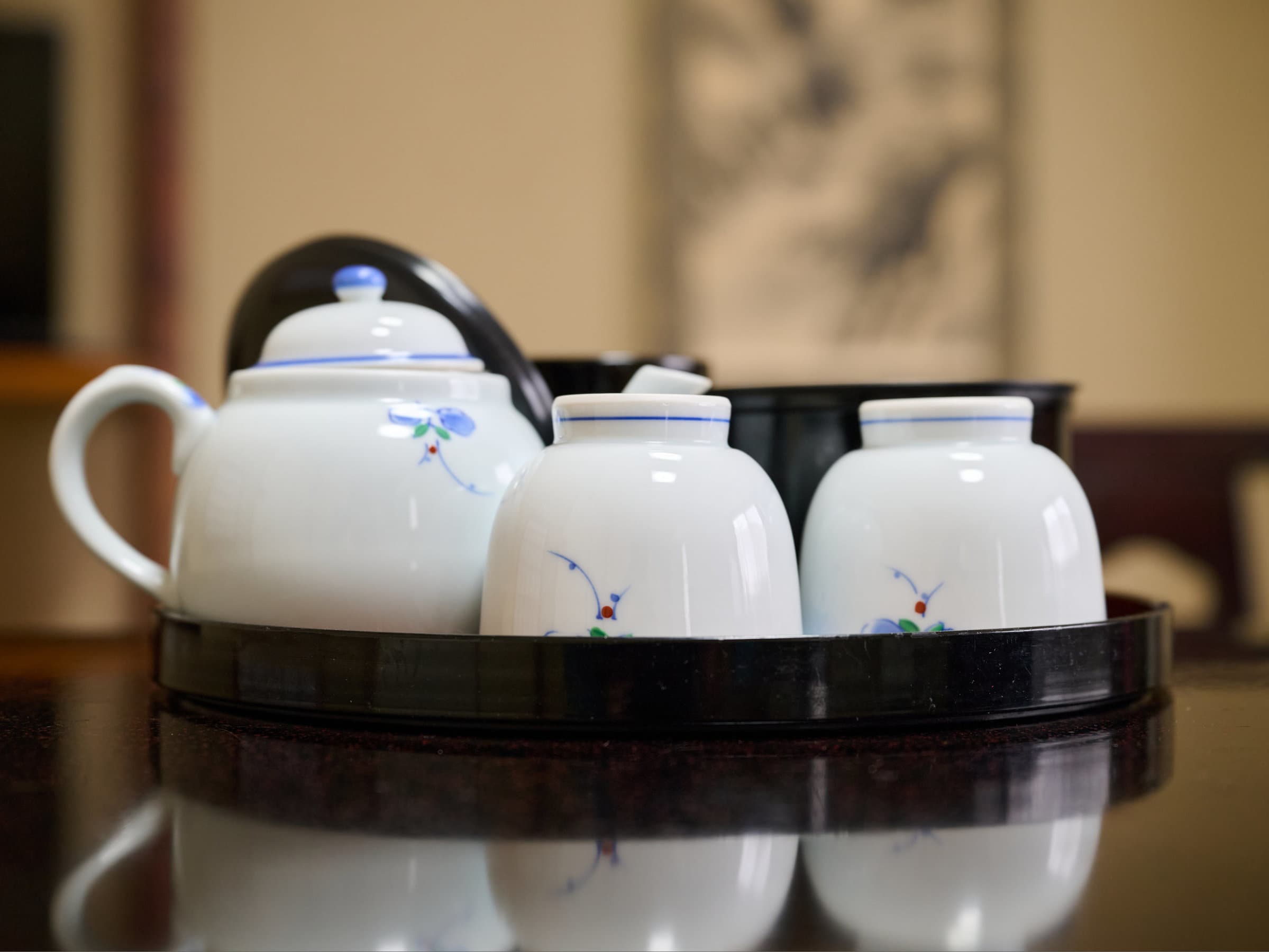 Close-up of a porcelain tea set on a lacquer tray, an in-room detail at Oyado Kiyomizuya, Noboribetsu