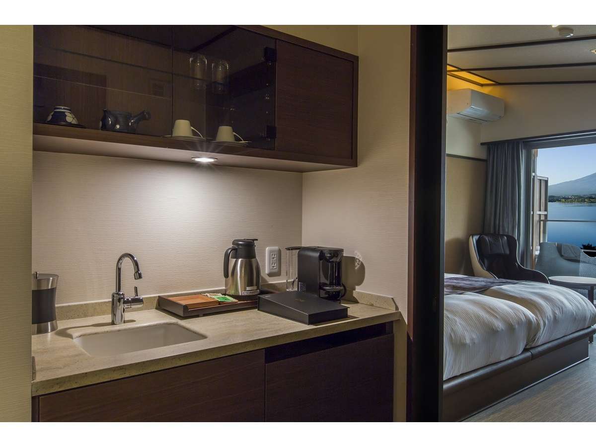 In-room pantry at Sunnide Resort with a sink, kettle and coffee maker beside a bedroom opening onto a Lake Kawaguchiko view