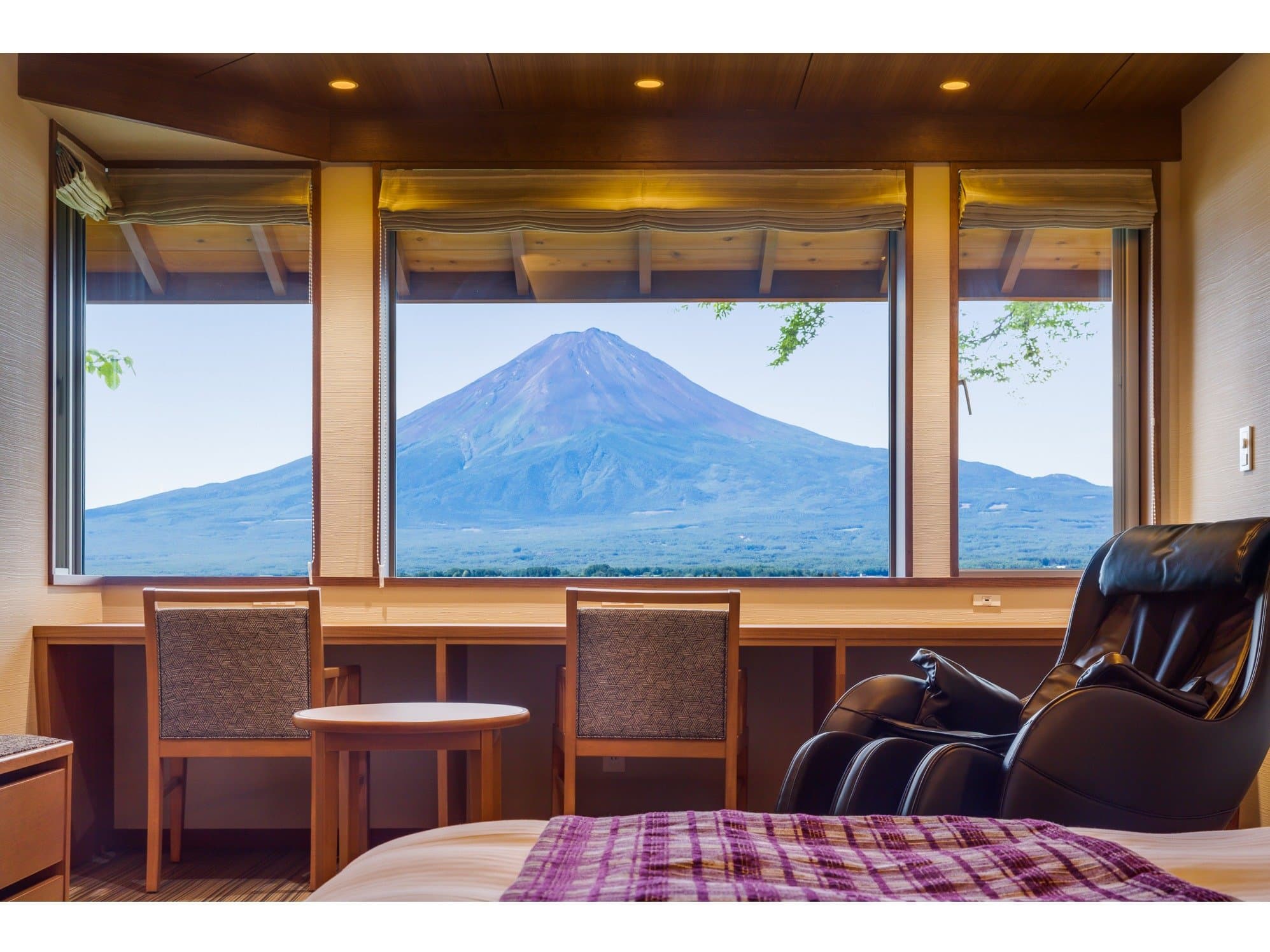 Premium guest room at Sunnide Resort with three large windows looking out to Mt Fuji and a reclining massage chair