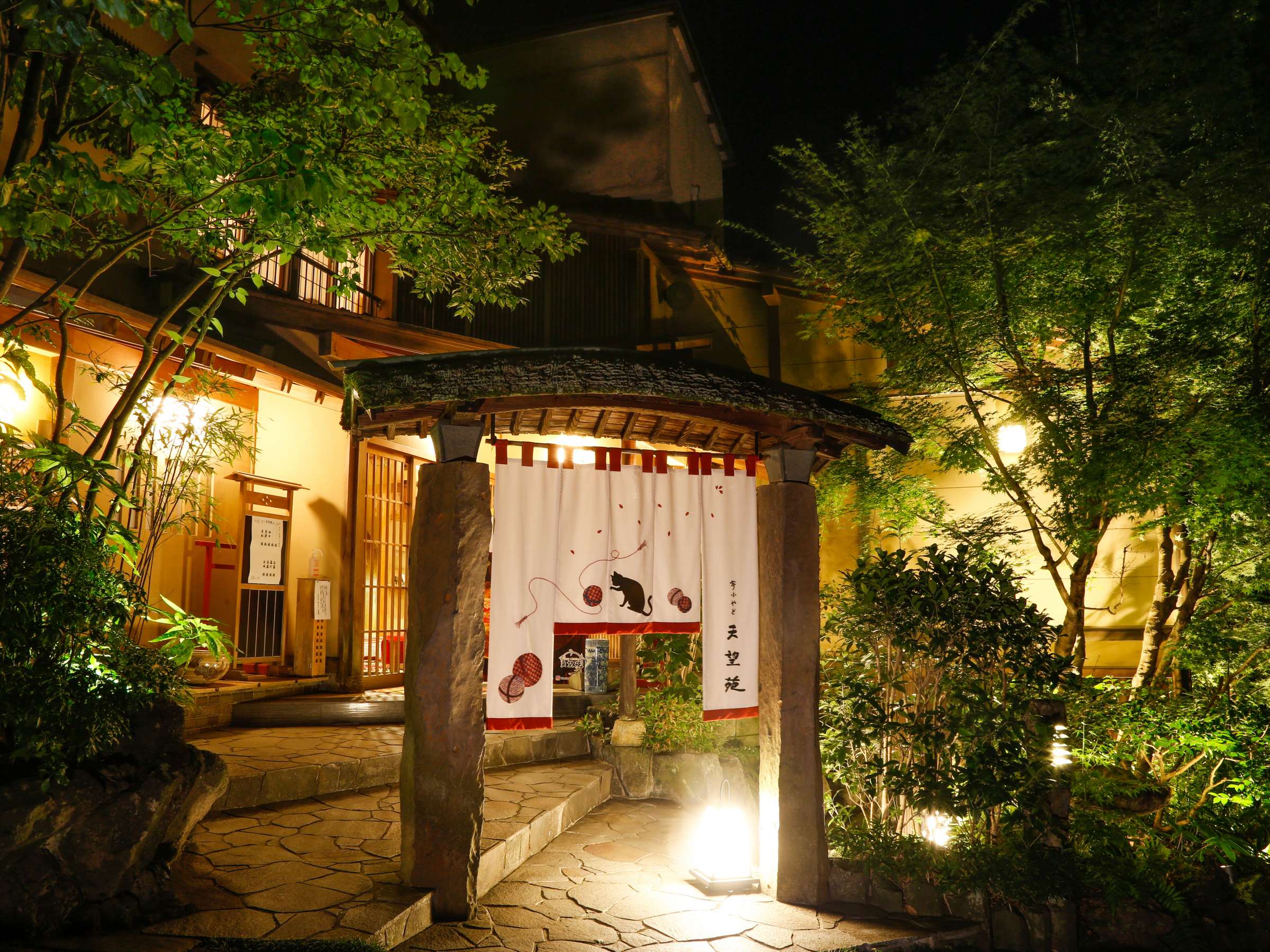 Yumekoyado Tenbouen Kinosaki Onsen entrance and garden lit up at dusk