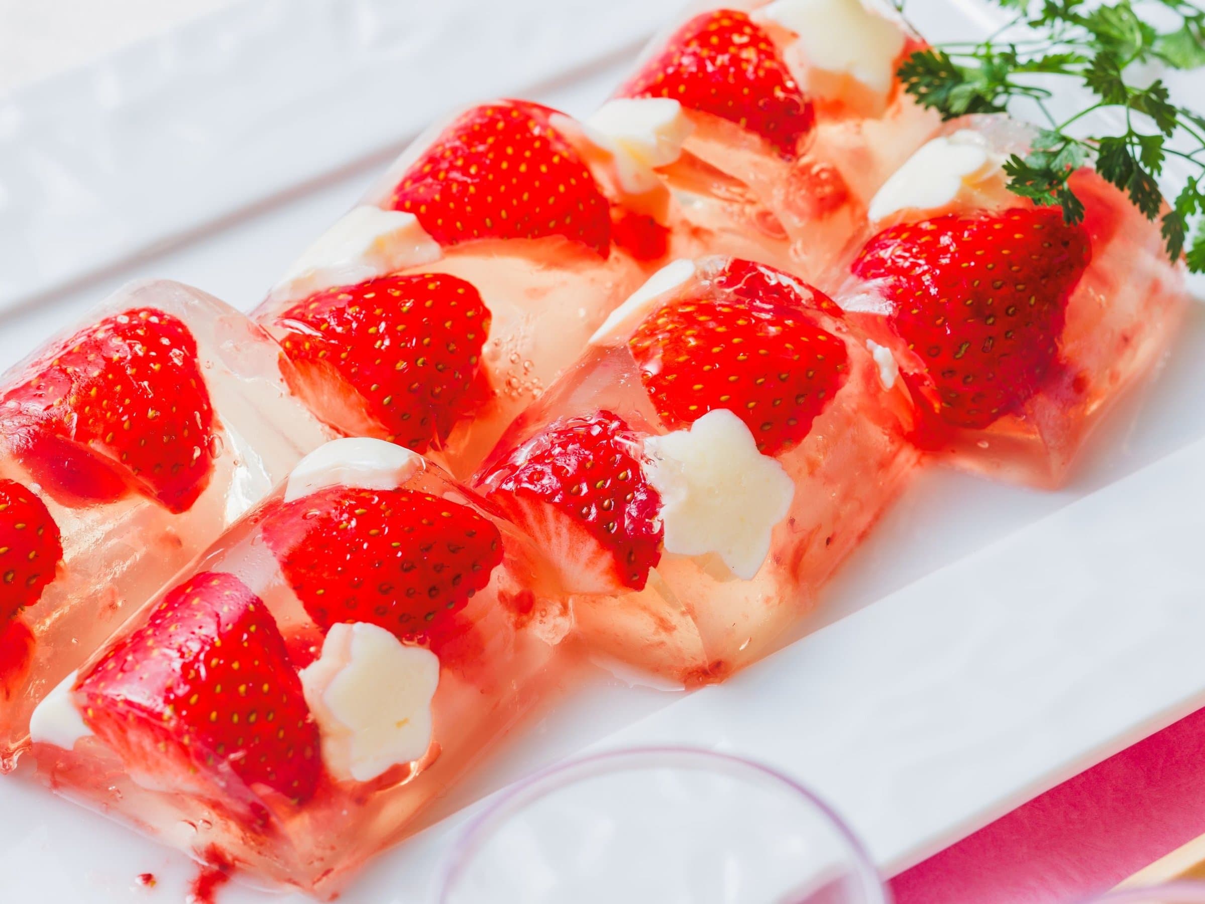 Strawberry and jelly dessert garnished with cream and herbs on a white plate at Hotel Jurin