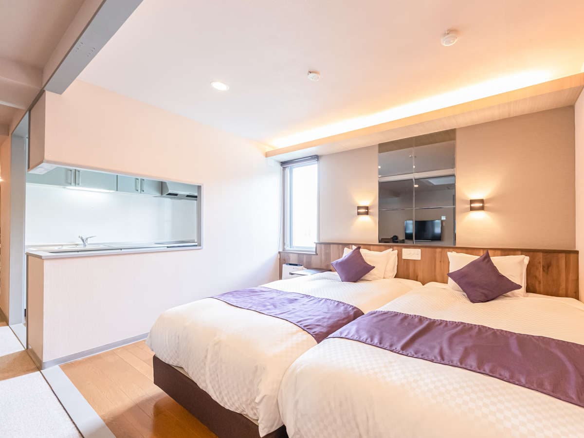 Modern Japanese-Western suite with twin beds, purple runners and a kitchenette area