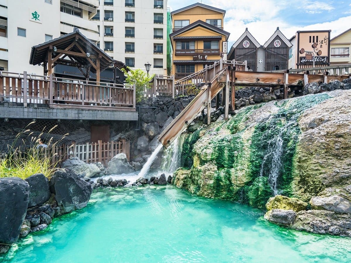 Kusatsu Yubatake hot-spring field with emerald water cascading over sulfur-coated rocks