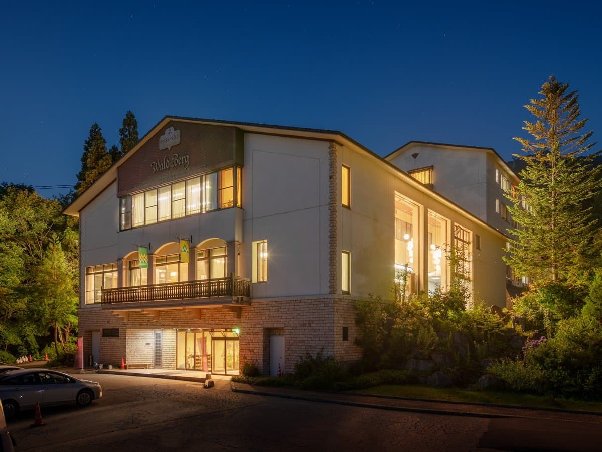 Sakaiya Mori no Hotel Waldberg illuminated exterior at dusk against the forested Zao Onsen hillside