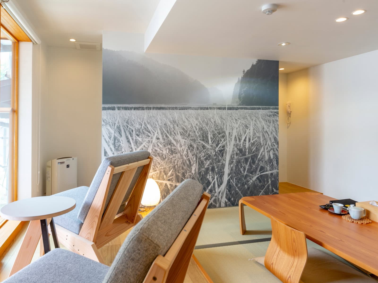 Modern tatami room with reed-field photographic mural and cedar lounge seating, Kawaguchiya Honkan, Kinosaki Onsen