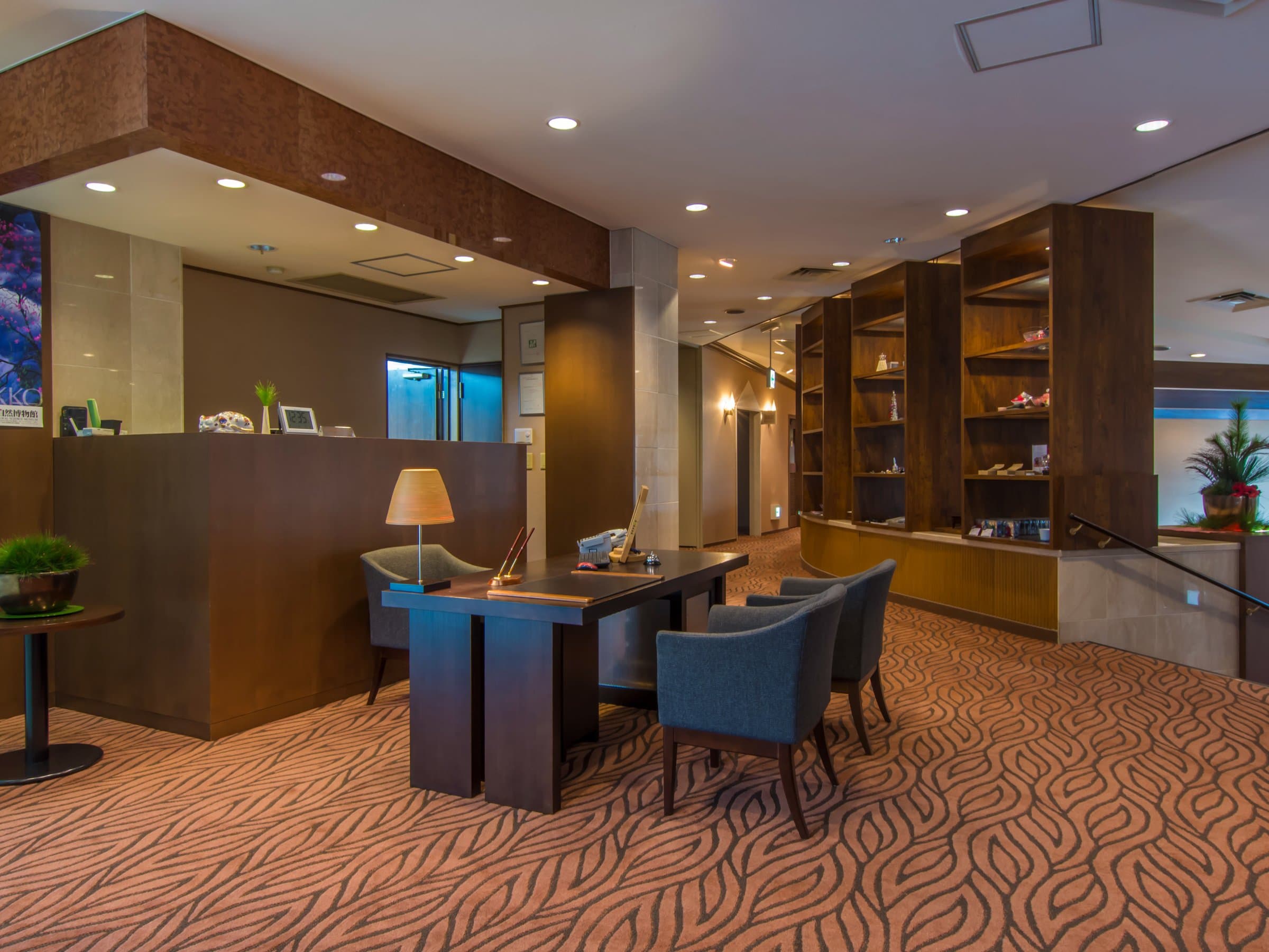 Lobby and reception area with a library lounge and patterned carpet at Hotel Hana-An