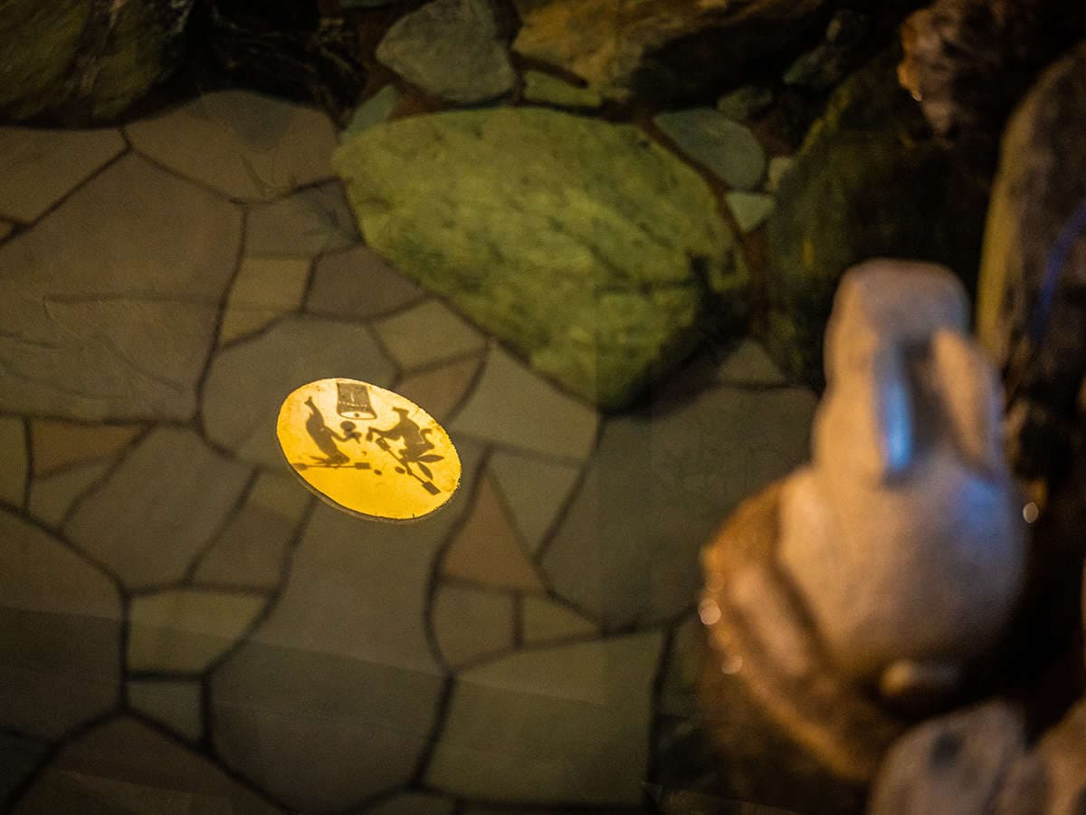 Atmospheric stone-paved rotenburo detail at night with stepping stones and soft golden lantern glow, Ryotei Matsubaya, Beppu Onsen