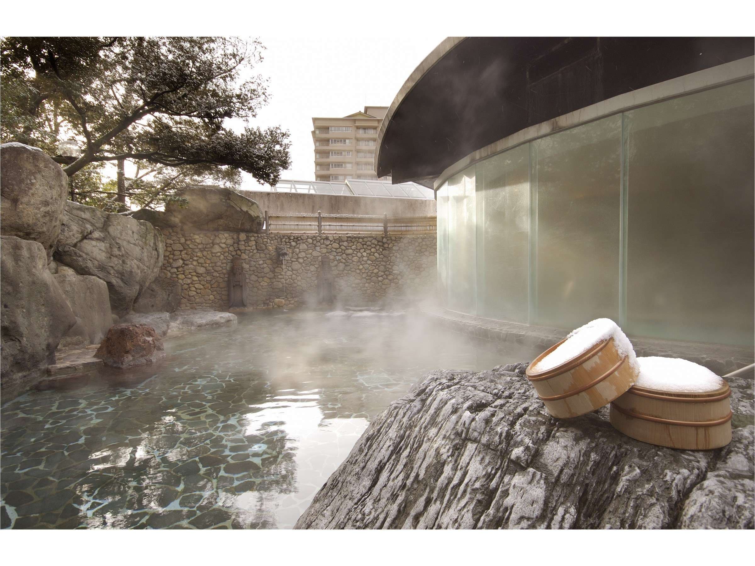 Steaming open-air rotenburo bath edged by natural rock under winter snow, Suimeikan, Gero Onsen