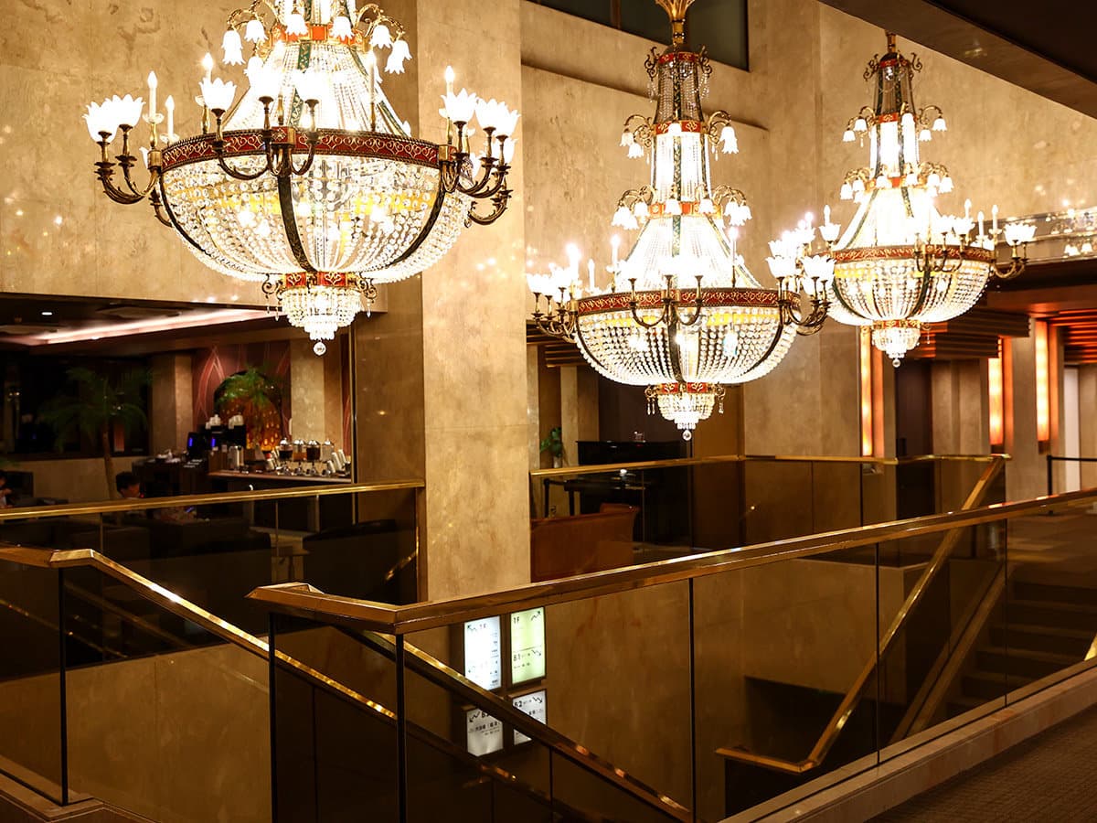 Hotel lobby lounge with ornate crystal chandeliers and a stone-clad column