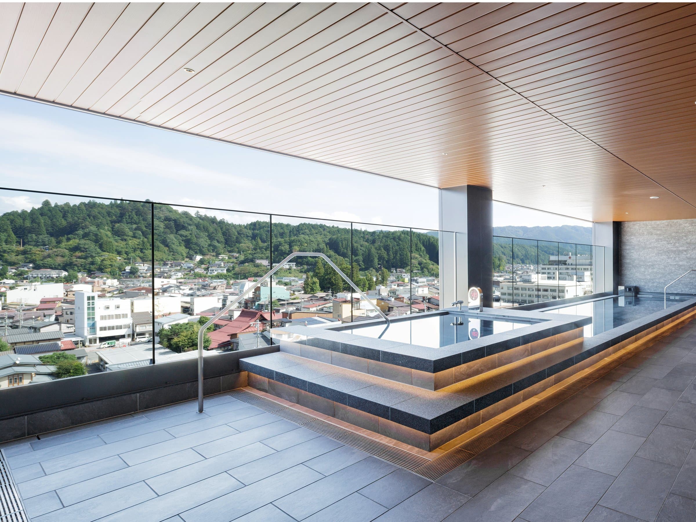 Rooftop open-air bath at HOTEL AMANEK Hida Takayama overlooking the Takayama townscape and mountains