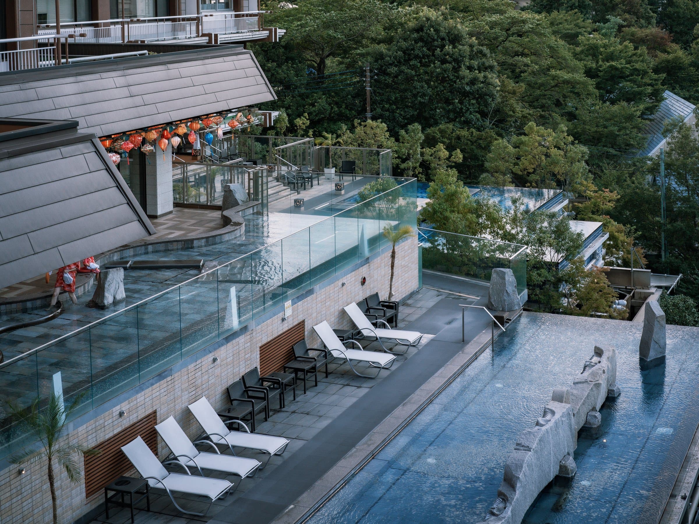 Outdoor infinity spa pool and wet deck with loungers overlooking the forested Kinugawa hillside