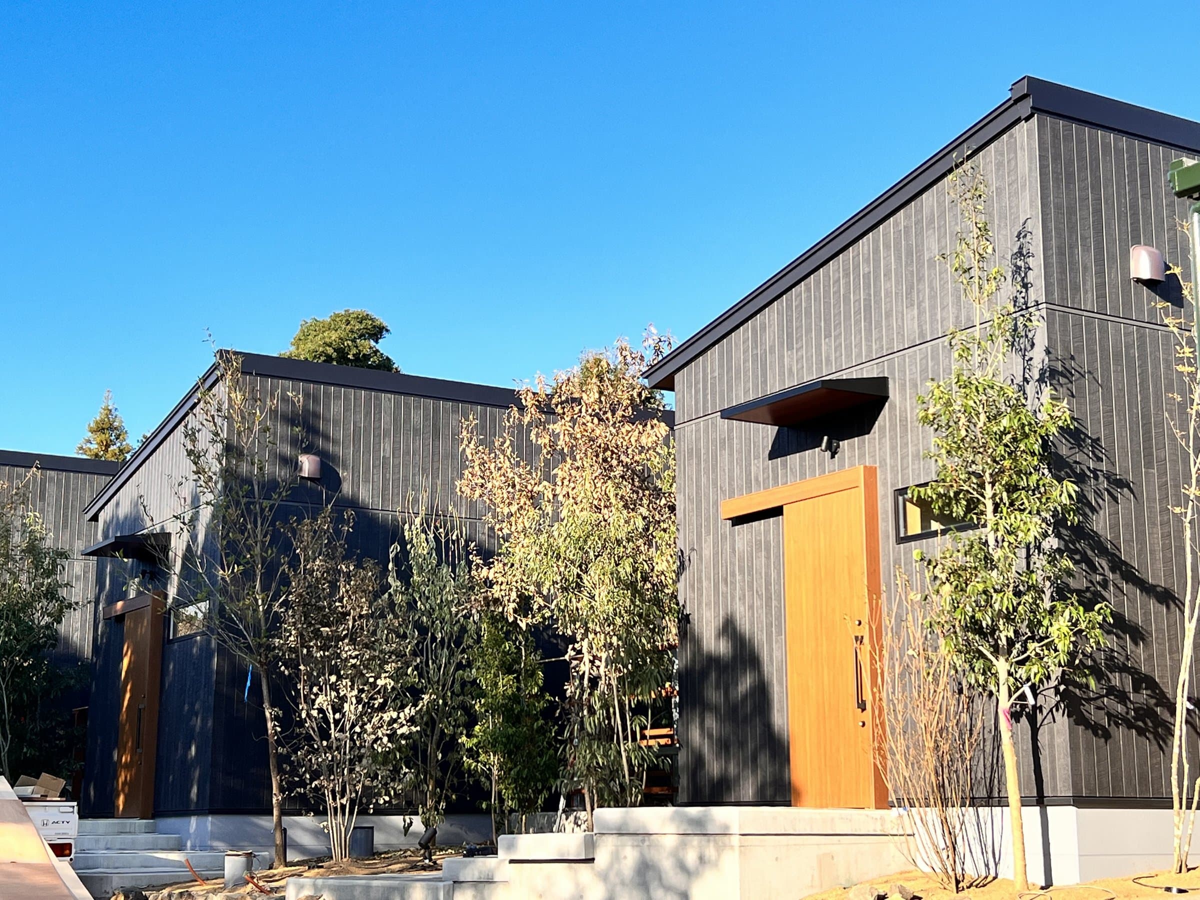 Modern dark-cedar detached villa buildings of Yamanote Bettei Hagakure under clear blue sky in Dogo, Matsuyama
