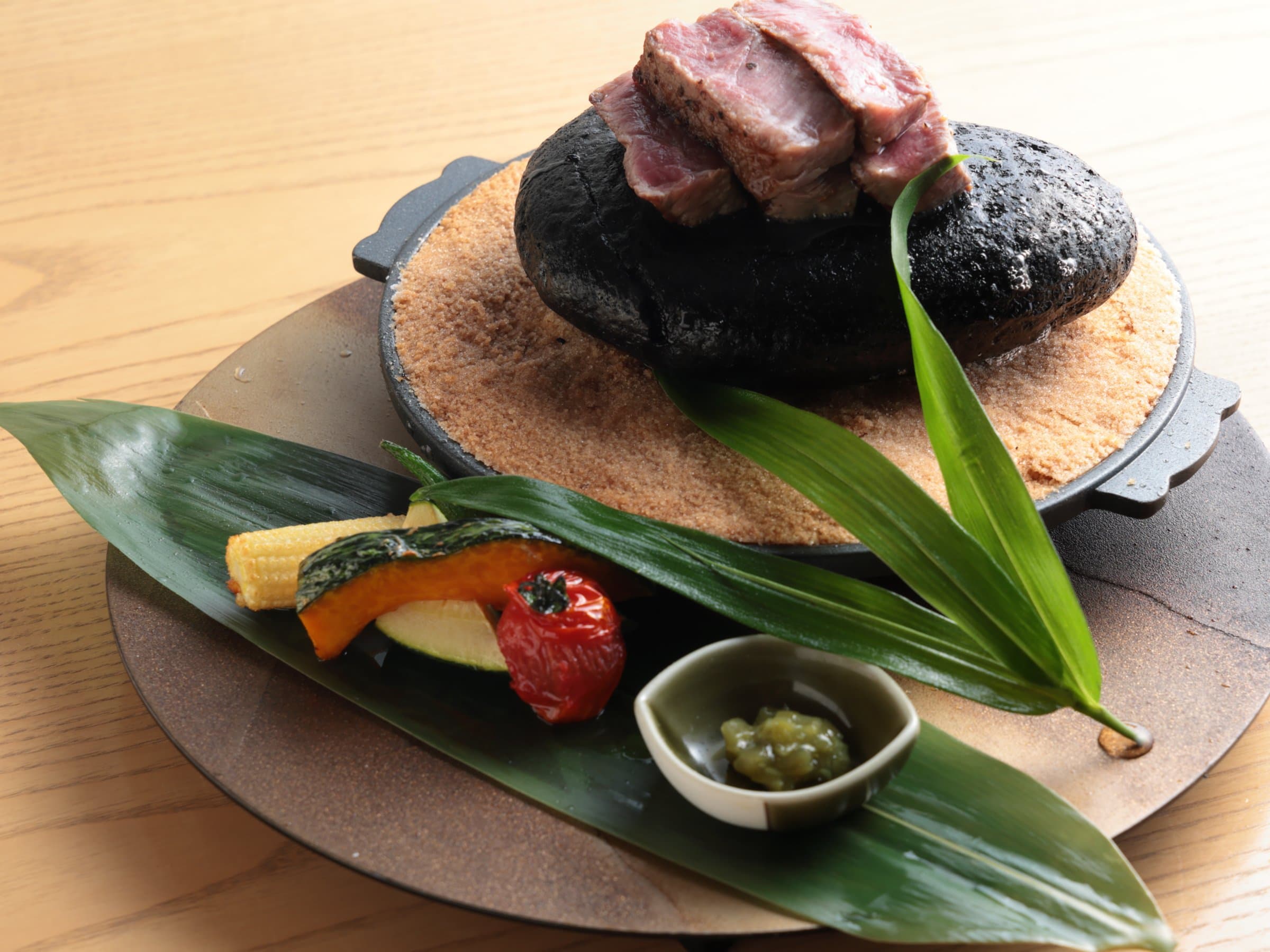 Stone-grilled wagyu beef with seasonal vegetables on a leaf at Bisei Yufuin
