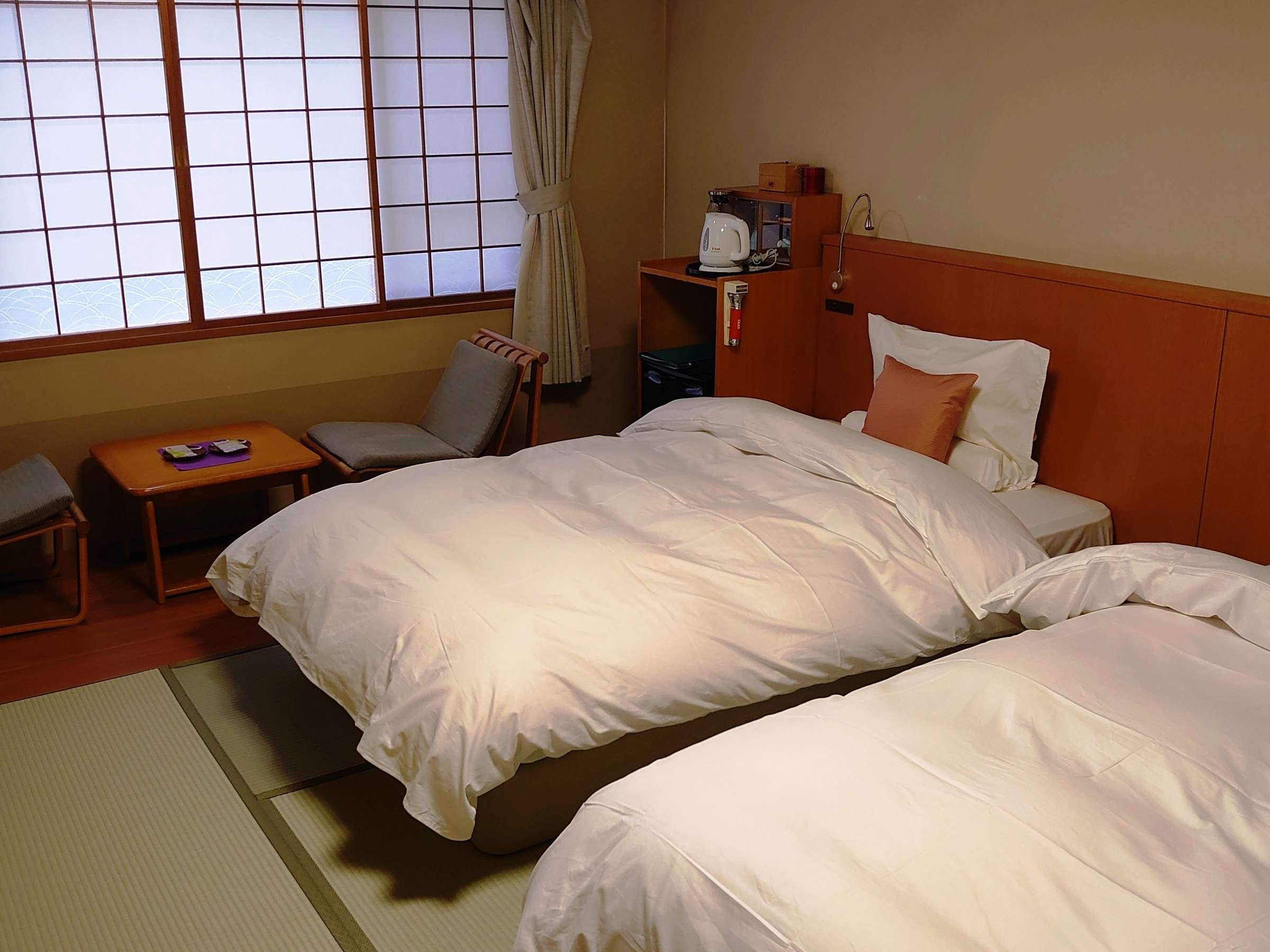 Japanese-Western twin guest room with low beds on tatami flooring and shoji windows at Tamanoyu, Noboribetsu Onsen