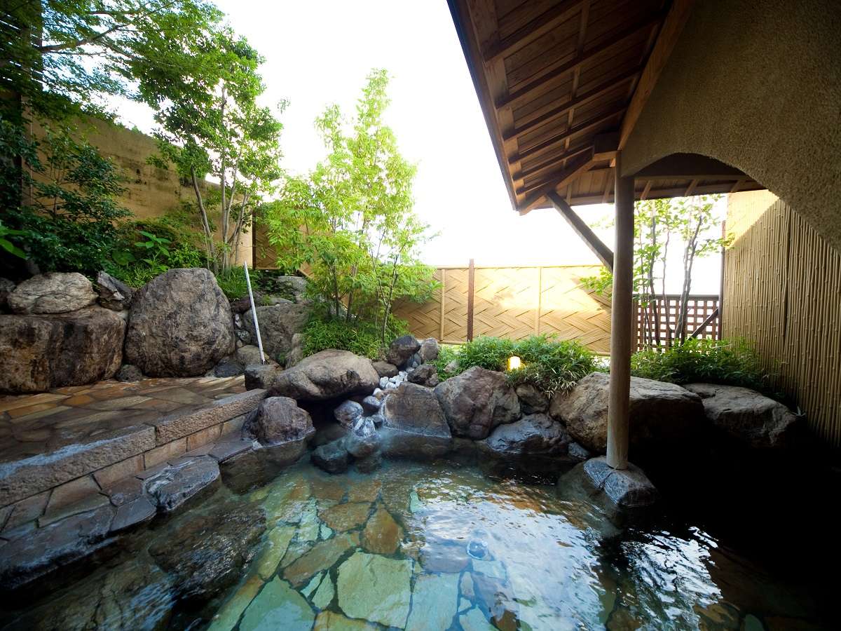 Spacious open-air rotenburo bath filled with natural hot spring water in an airy relaxed setting, Ryokan Chobonoyado Shiori, Beppu Onsen