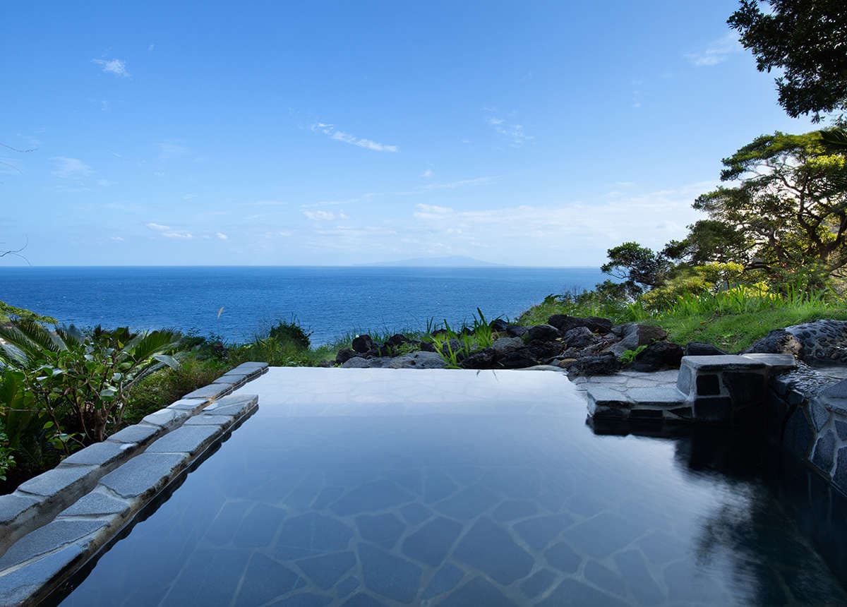 Ocean-view open-air stone rotenburo at Kissho Caren overlooking the sea in Izu Inatori on a clear day