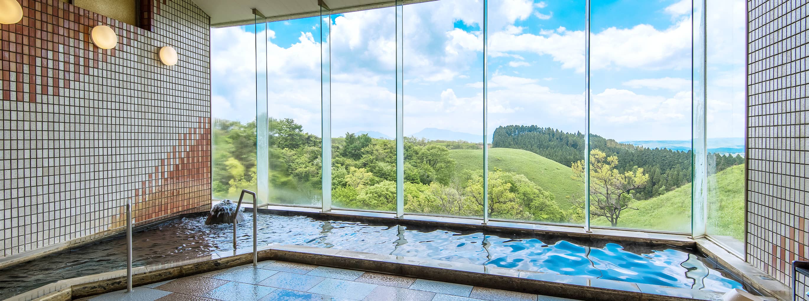 Large indoor public bath with floor-to-ceiling windows at Senomoto Highland's Hotel