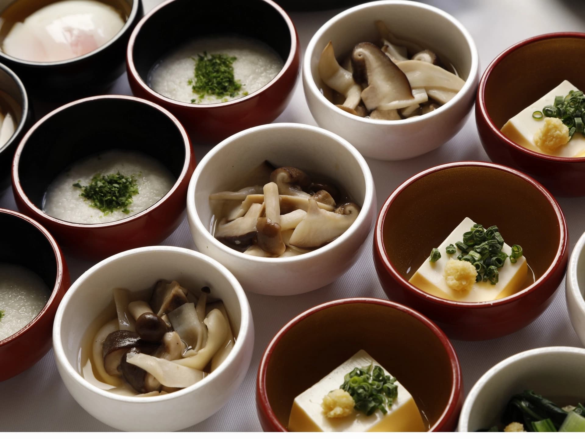 Japanese breakfast spread at Onyado Nono Nara with rice porridge, mushrooms and chilled tofu in small bowls