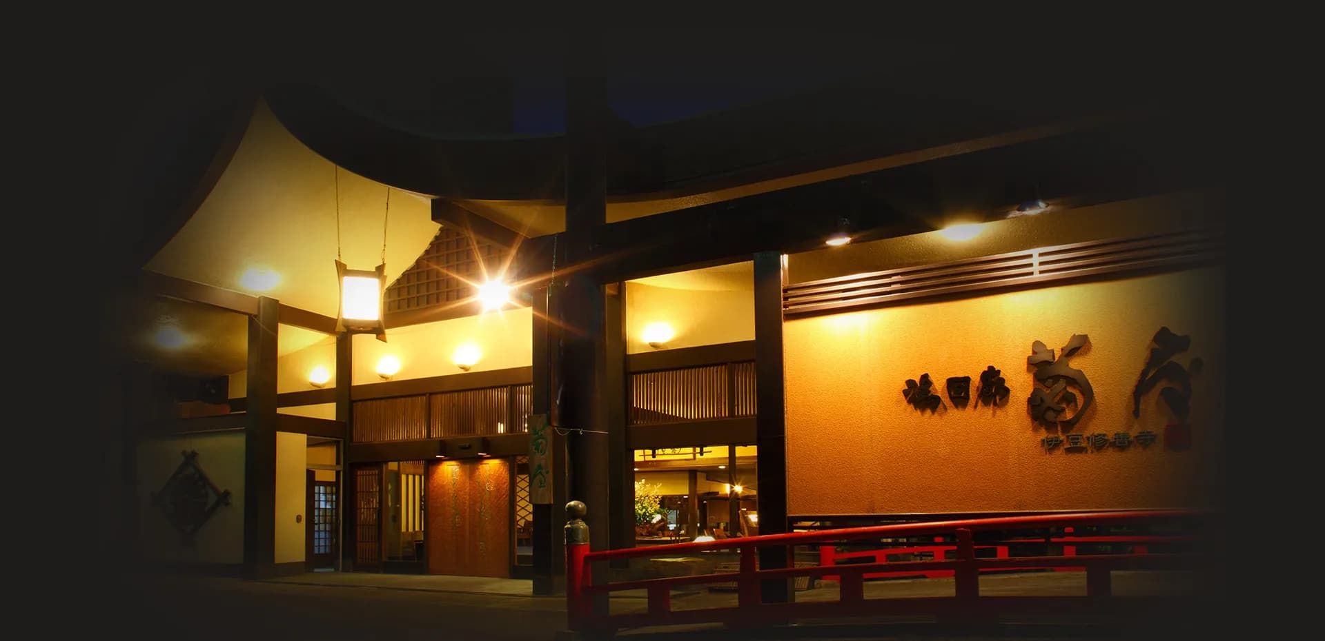 Yu-Kairo Kikuya ryokan illuminated wooden entrance at dusk in Shuzenji Onsen, Izu