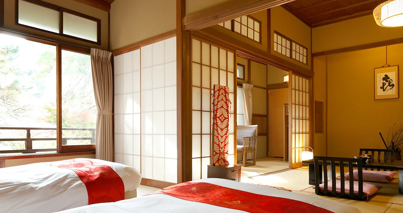 Traditional tatami guest room with futons and shoji screens facing the garden at Yu-Kairo Kikuya
