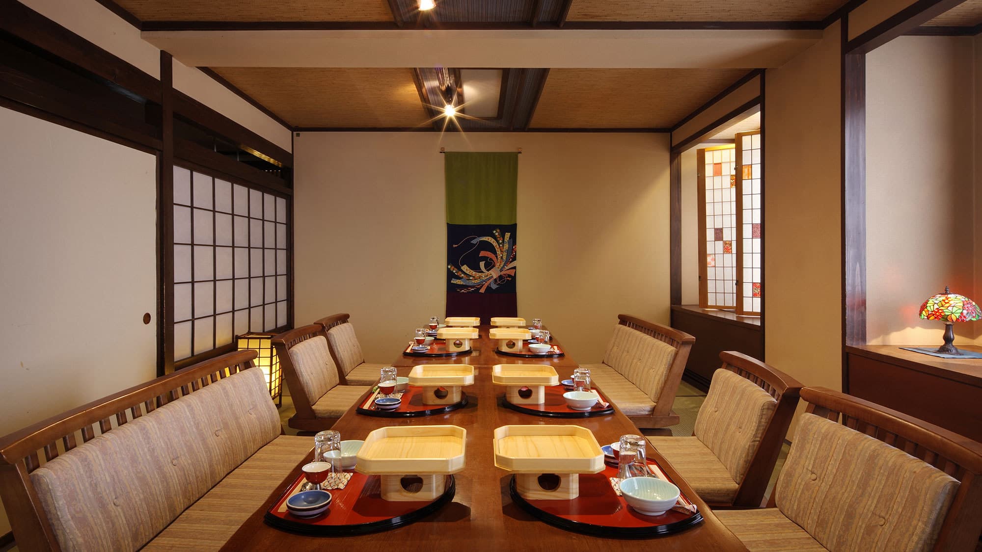 Private tatami dining room at Isshinkan set with lacquer trays, floor seating, shoji screens and a hanging scroll