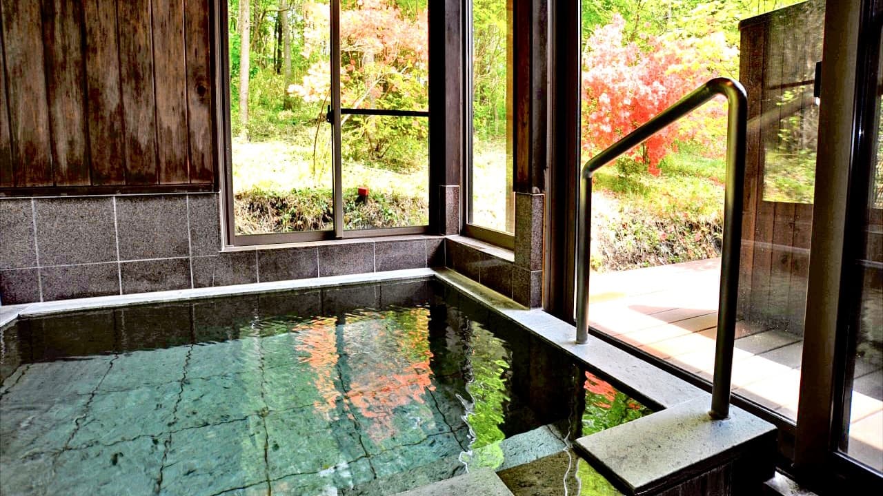 Private indoor stone bath with autumn foliage view