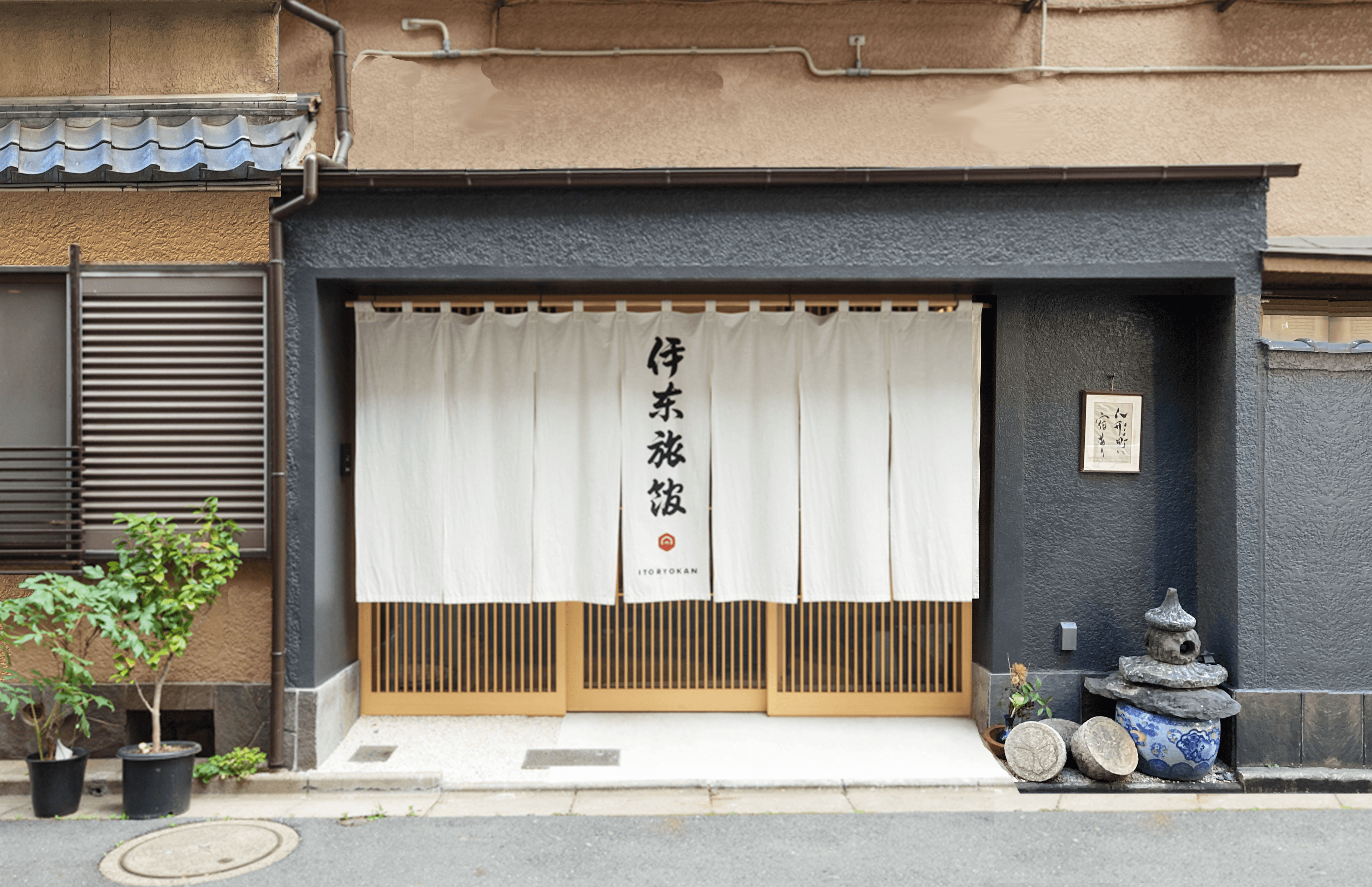 Street entrance of Ito Ryokan in Nihonbashi Tokyo with white noren curtain and stone lantern