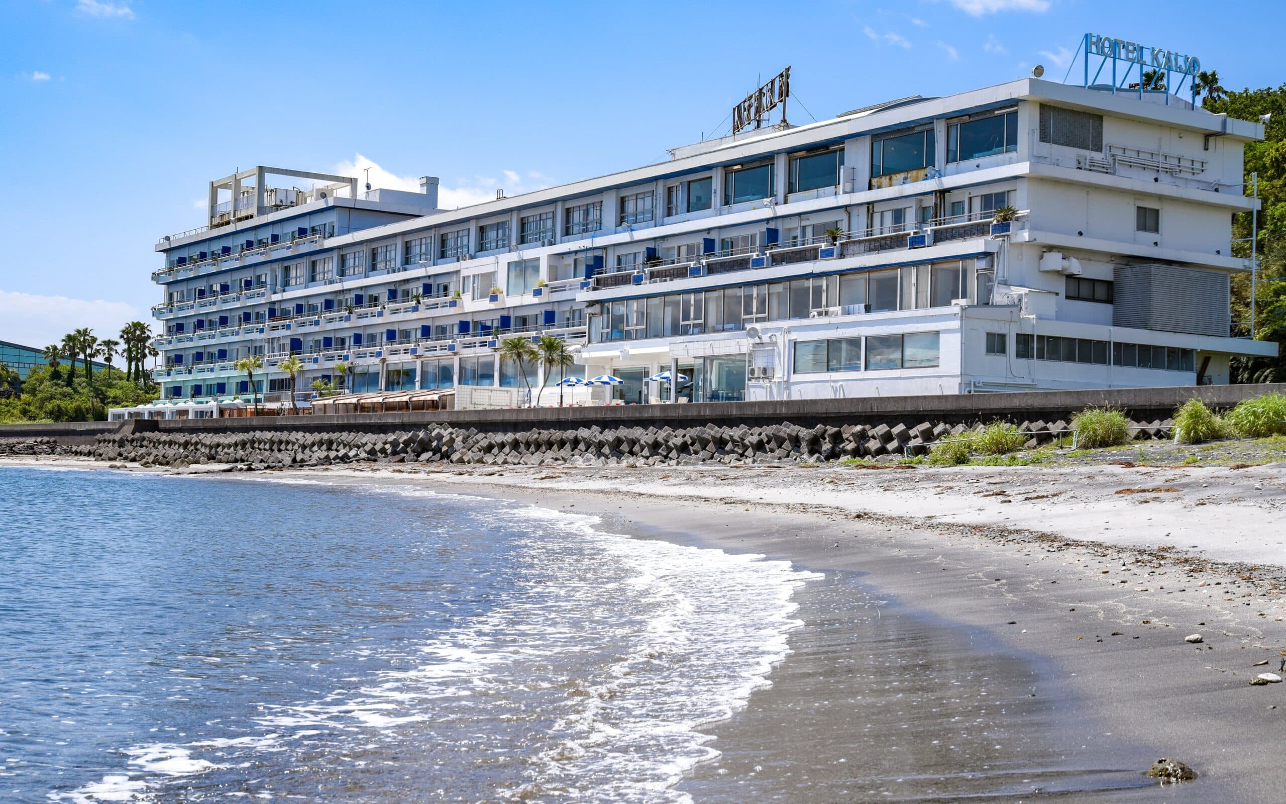 Ibusuki Kaijo Hotel seen from the sandy beach, its long white seafront building facing Kinko Bay in Ibusuki, Kagoshima