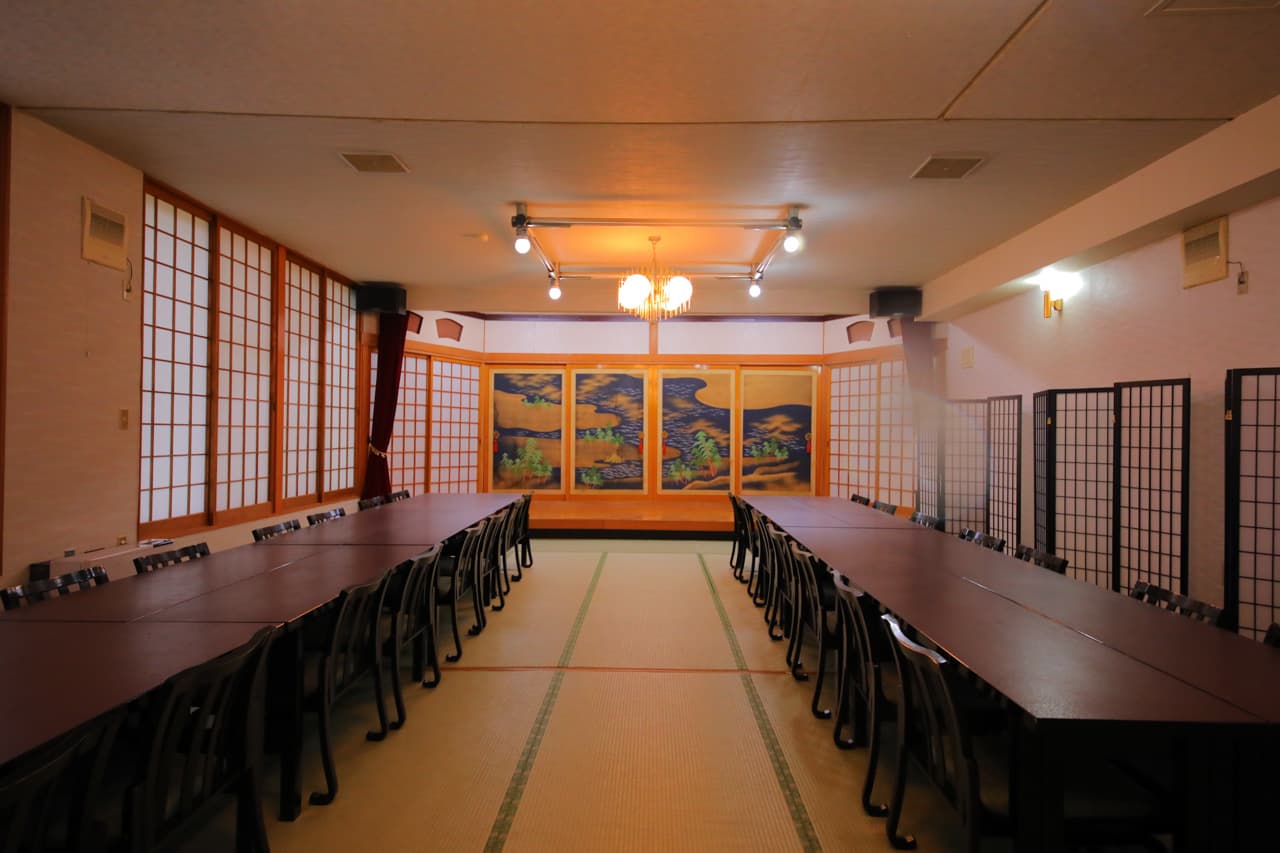 Large tatami banquet hall with shoji screens and a gilded folding screen at Sanseikan in Noboribetsu