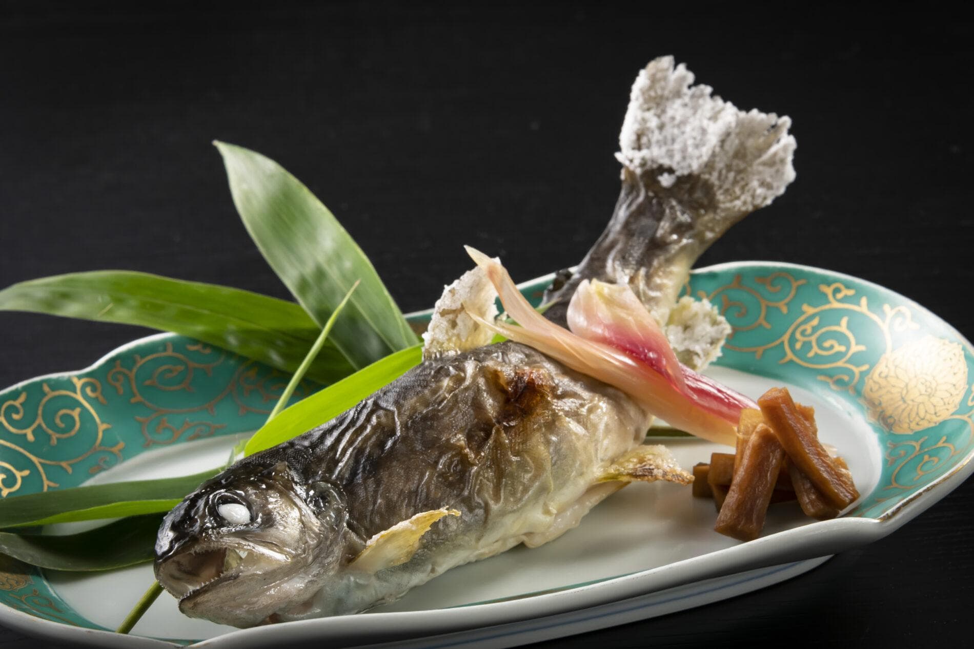 Salt-grilled river fish served on a decorative plate