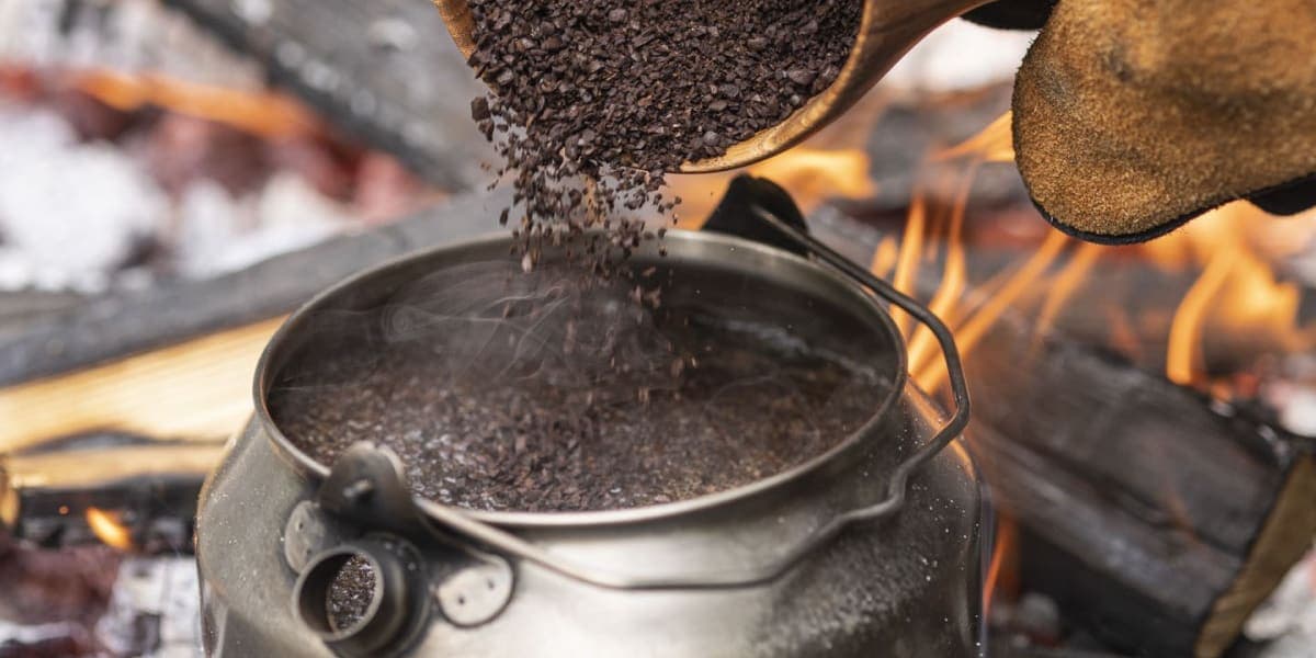 Coffee being brewed over an open campfire kettle at the HOSHINOYA Fuji forest kitchen