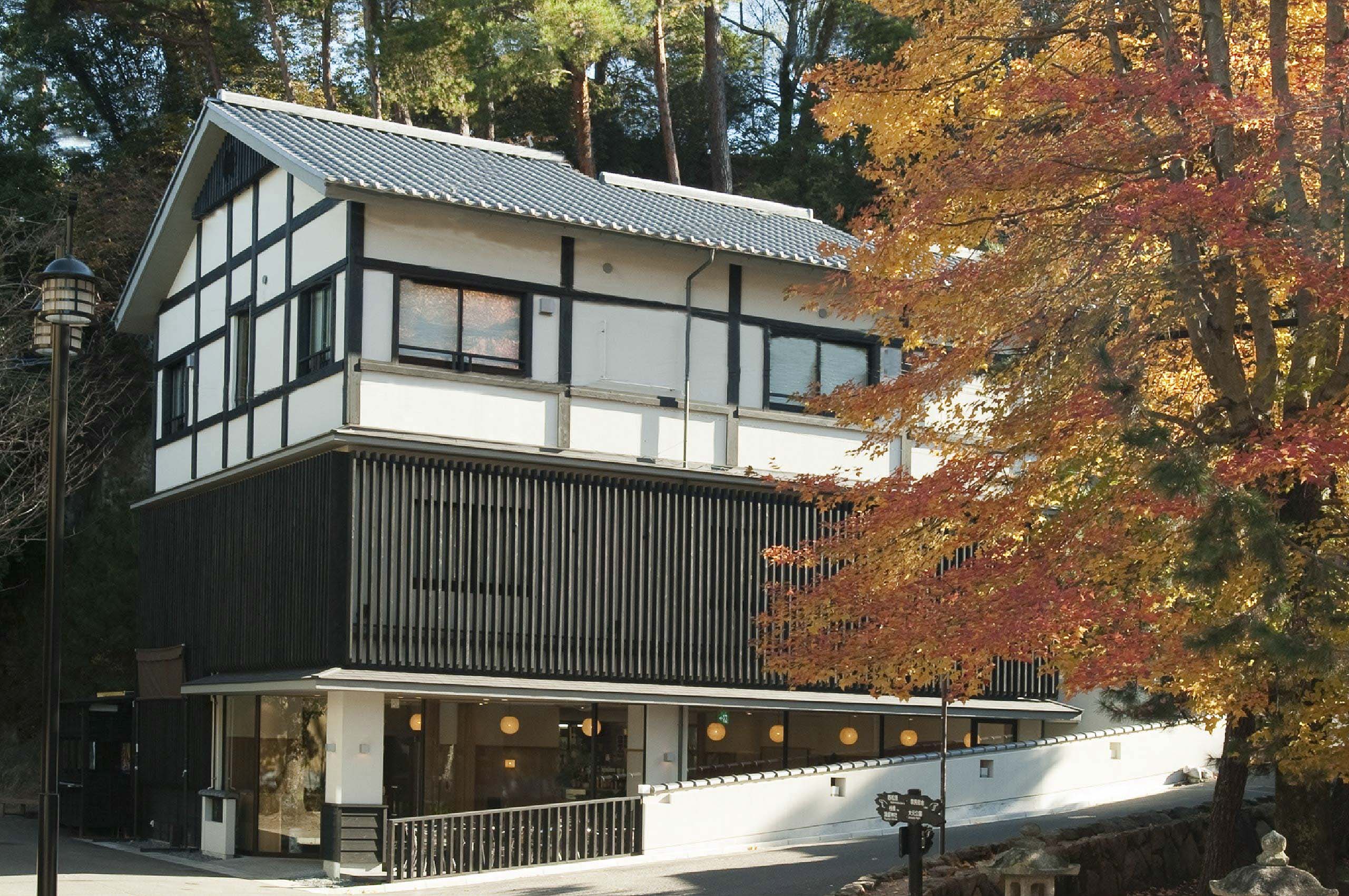 Mizuhaso ryokan three-storey timber and white-plaster exterior framed by autumn maples near Miyajima